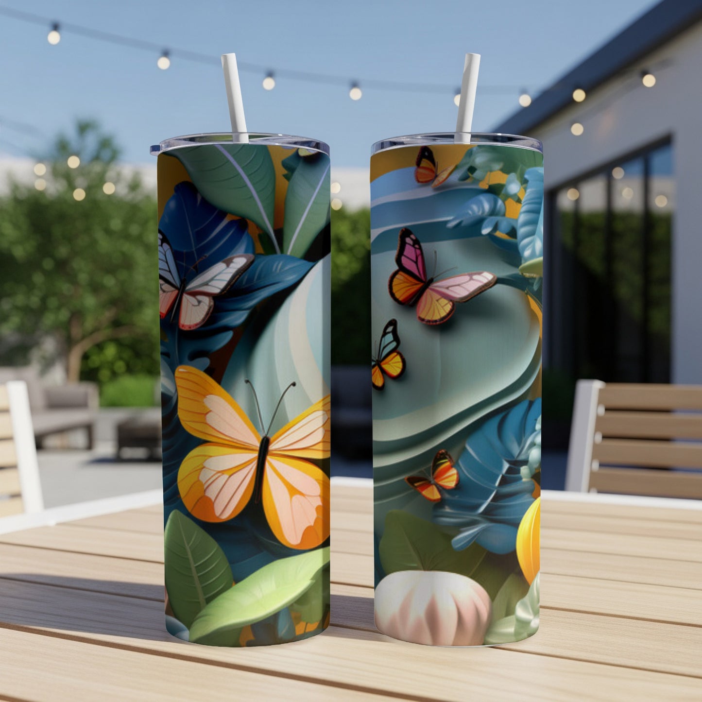 Two tumblers with butterflies and tropical leaves on an outdoor table.