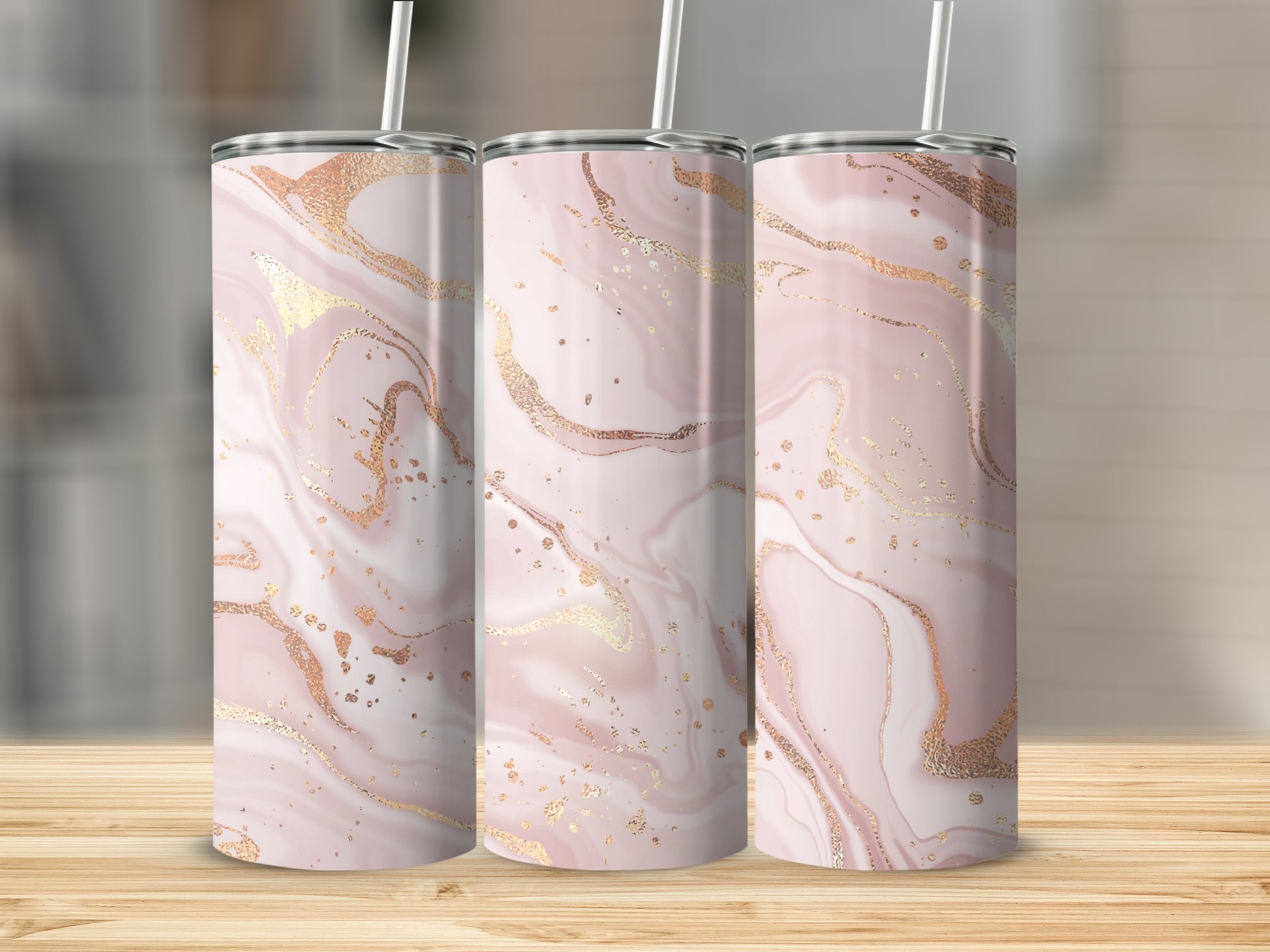 Three tumblers with a pink and gold marble pattern displayed on a wooden surface.