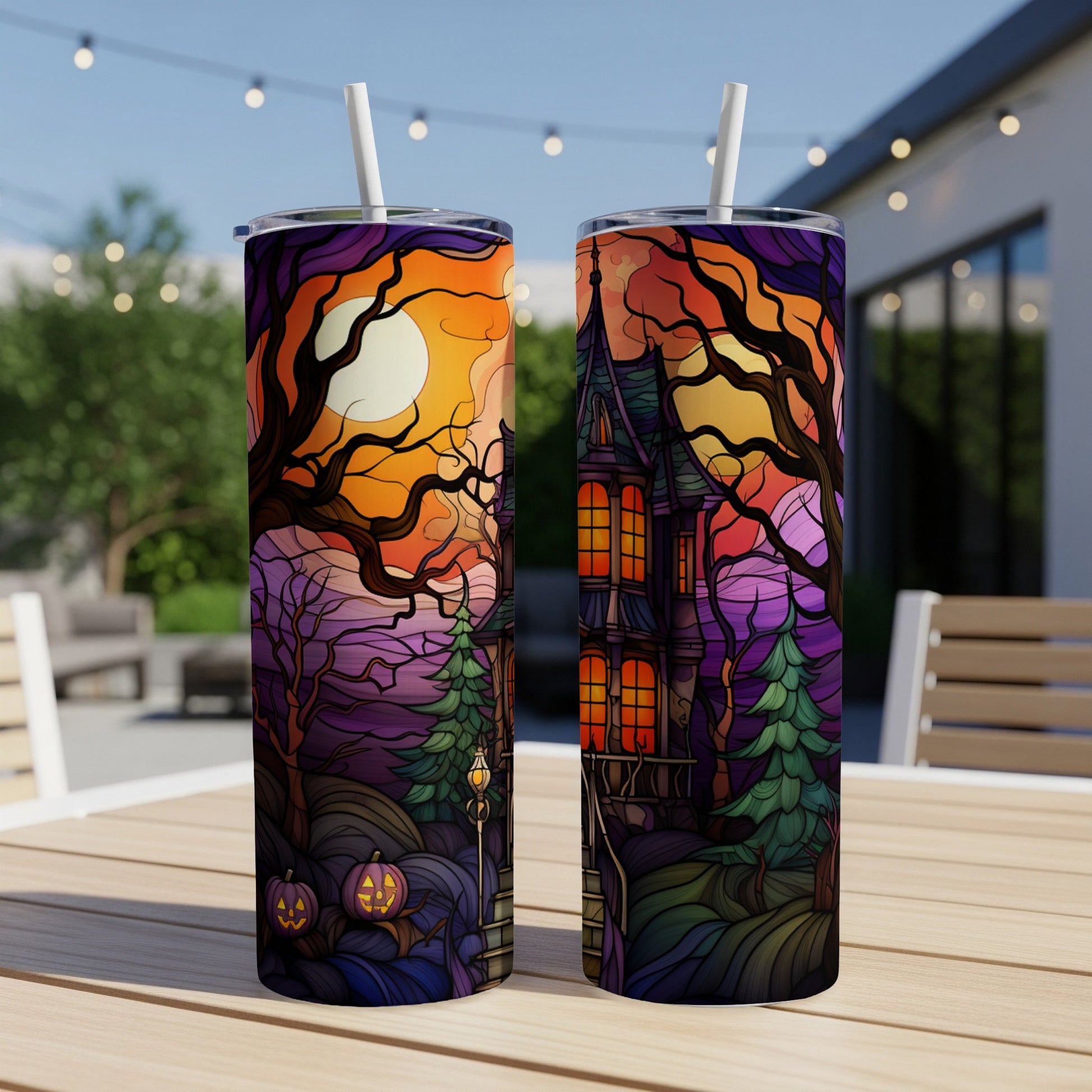 Spooky Halloween haunted house design on two tumblers outdoors.