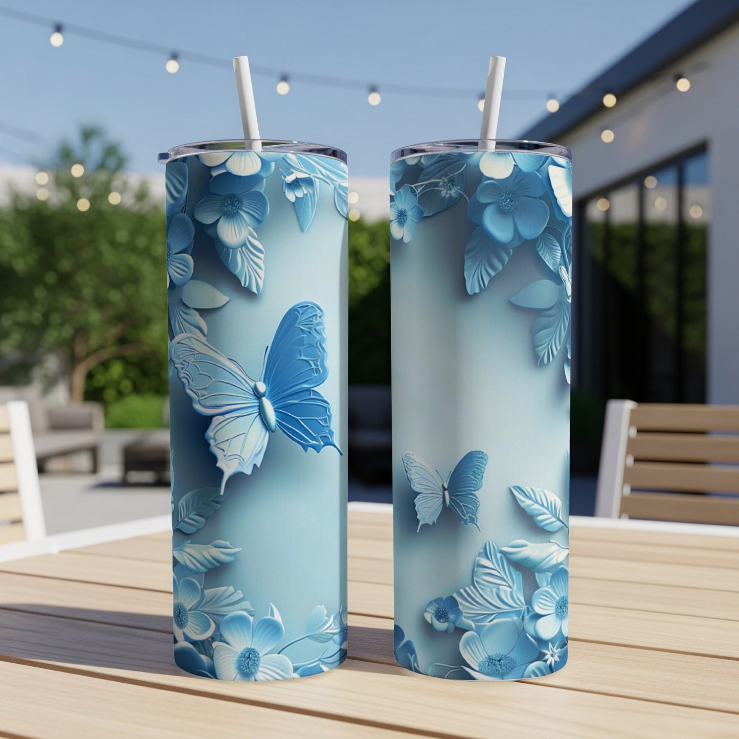 Two blue butterfly tumblers with floral designs on a wooden table.