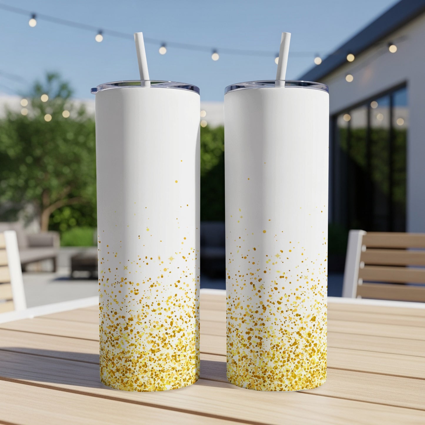 Two white tumblers with gold glitter accents on a wooden table.