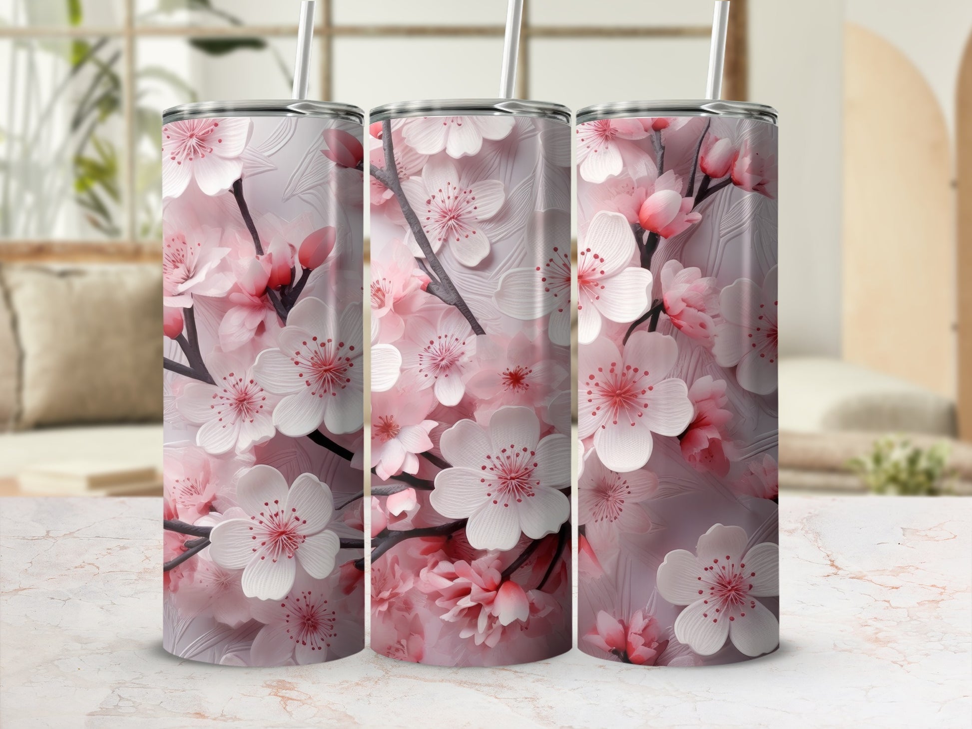Pink cherry blossoms on three tall tumblers with straws.
