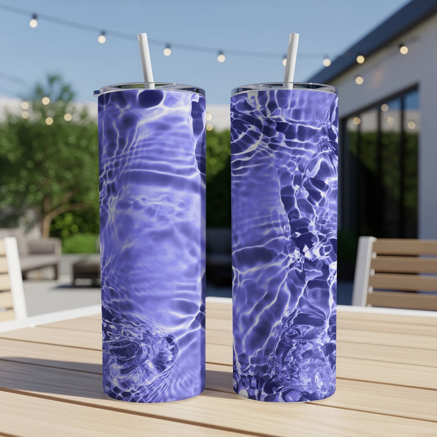 Two tumblers with ripple water pattern sit on a wooden table outdoors.