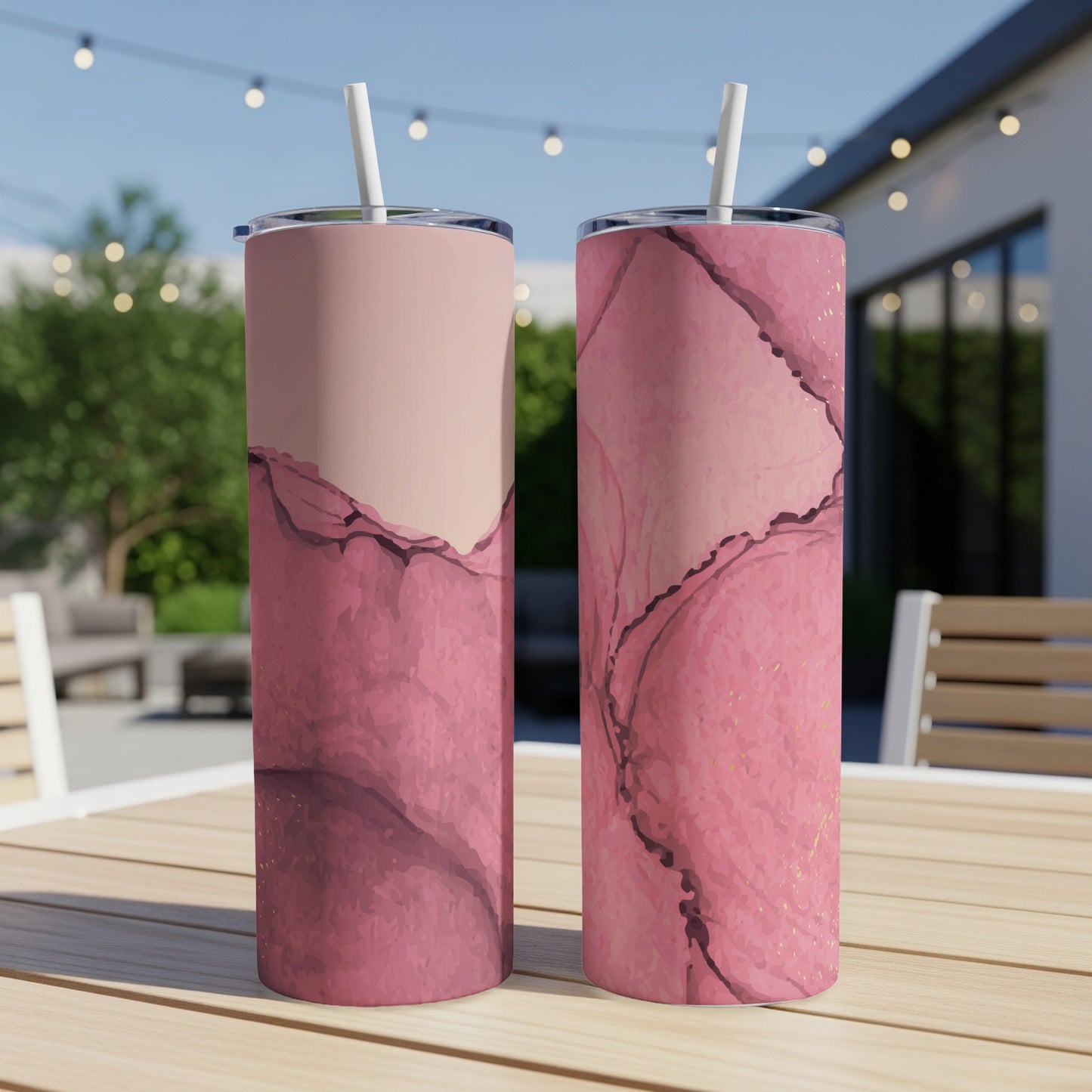 Two pink marble tumblers with gold accents on a table.