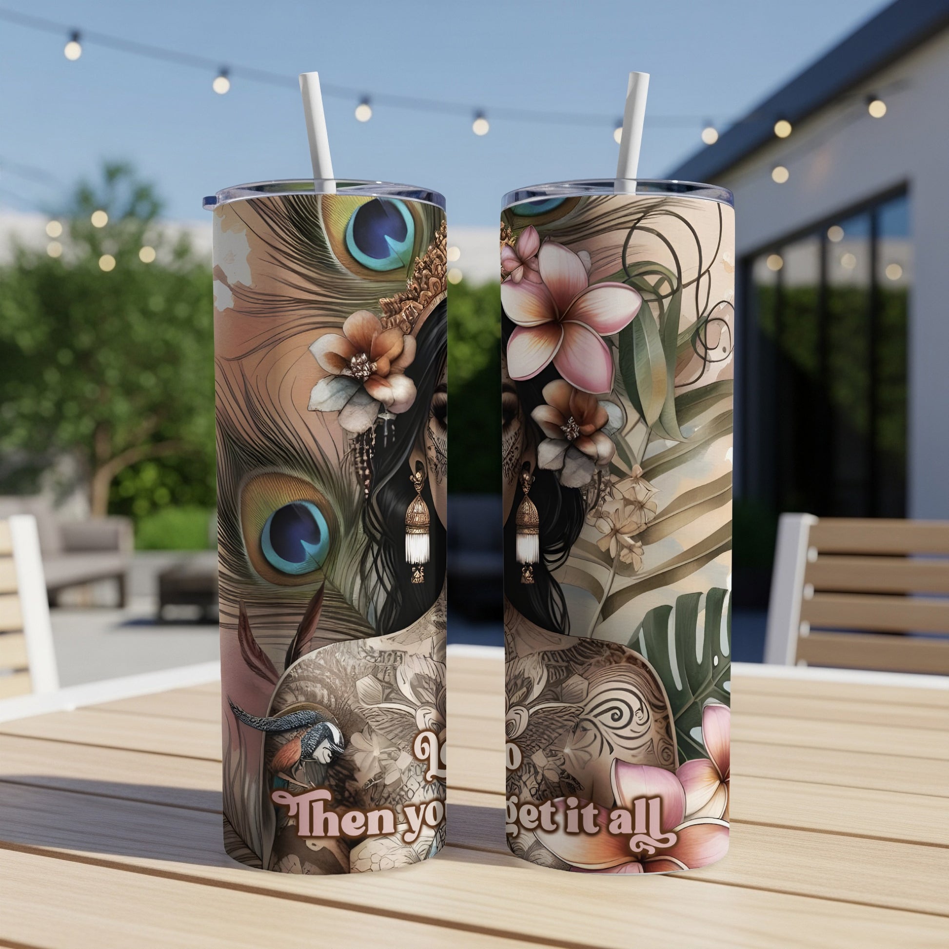 Two tumblers with floral and peacock feather designs sit on a table.