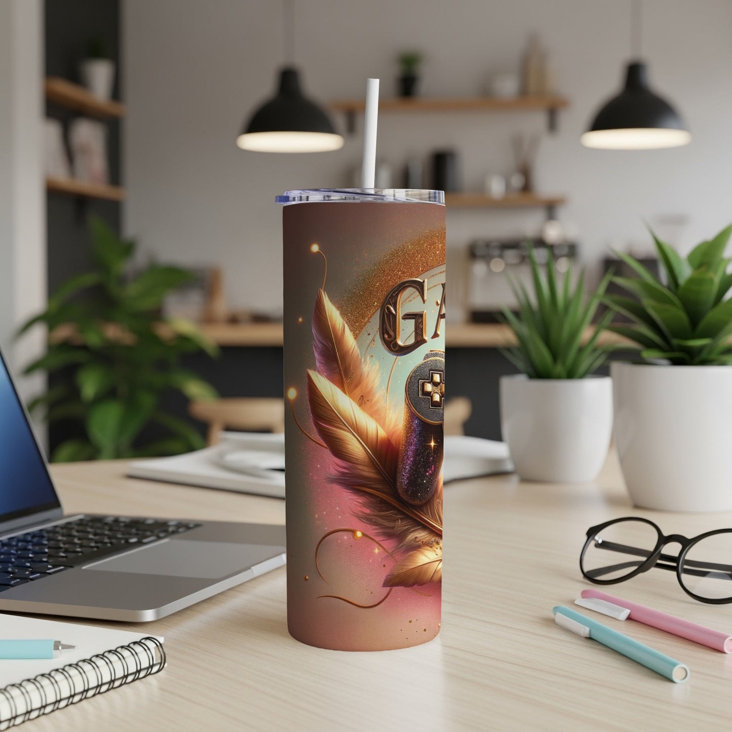 Glittery tumbler with feathers, controller, and "Gamer" text on a desk.