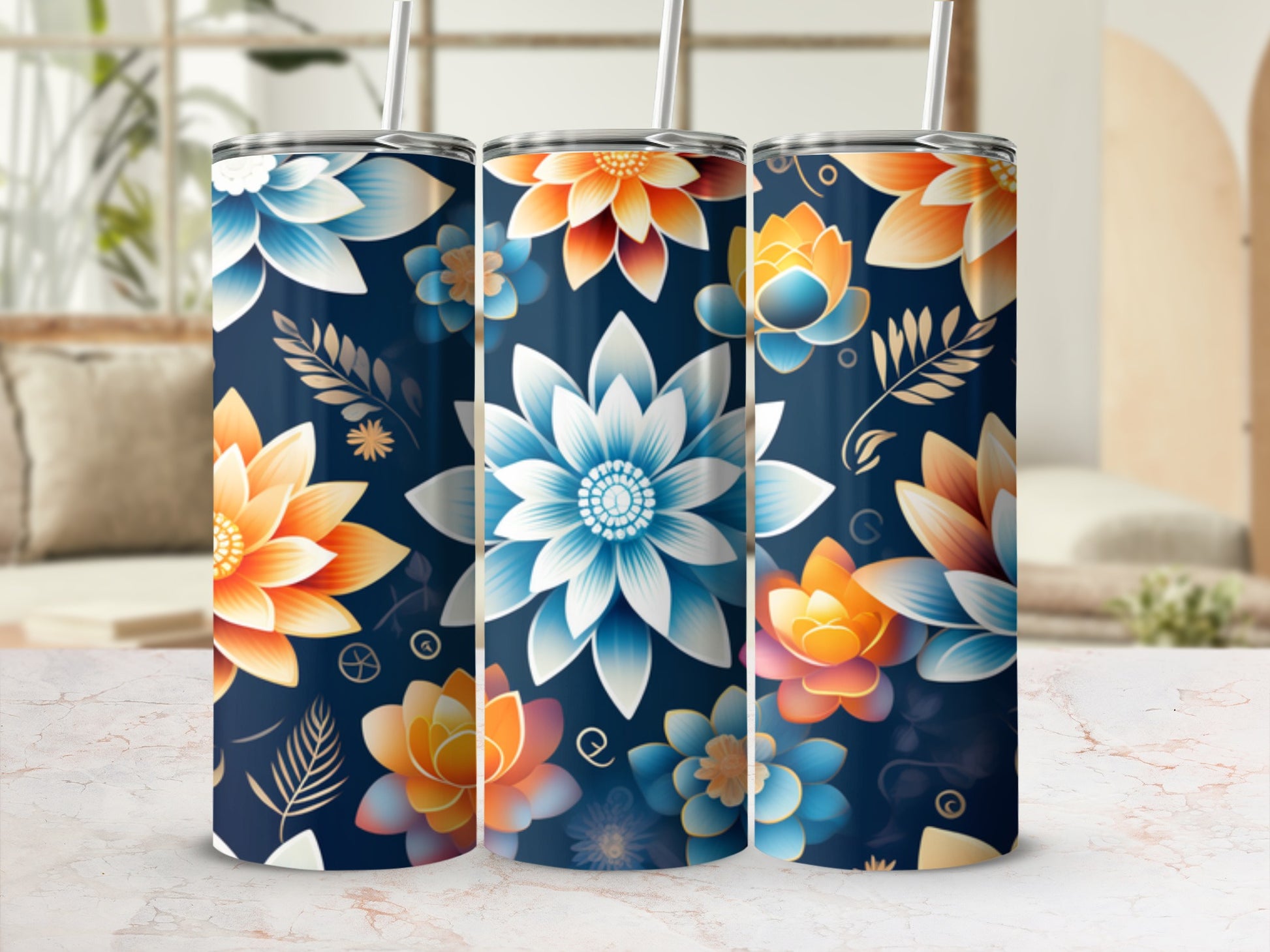 Three floral tumblers with straws on a marble surface.