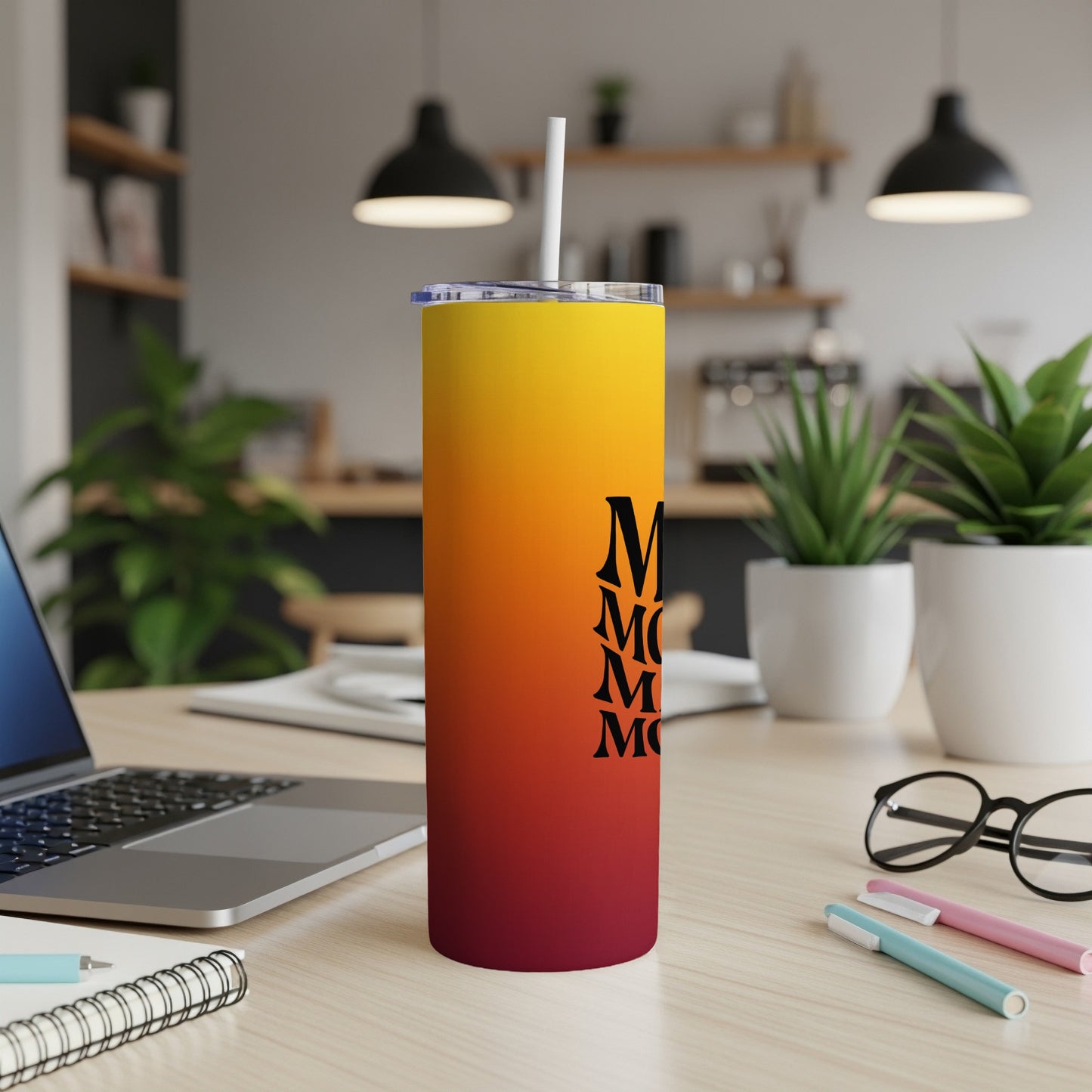 Gradient tumbler with "Mom" repeated in black text, resting on a desk.