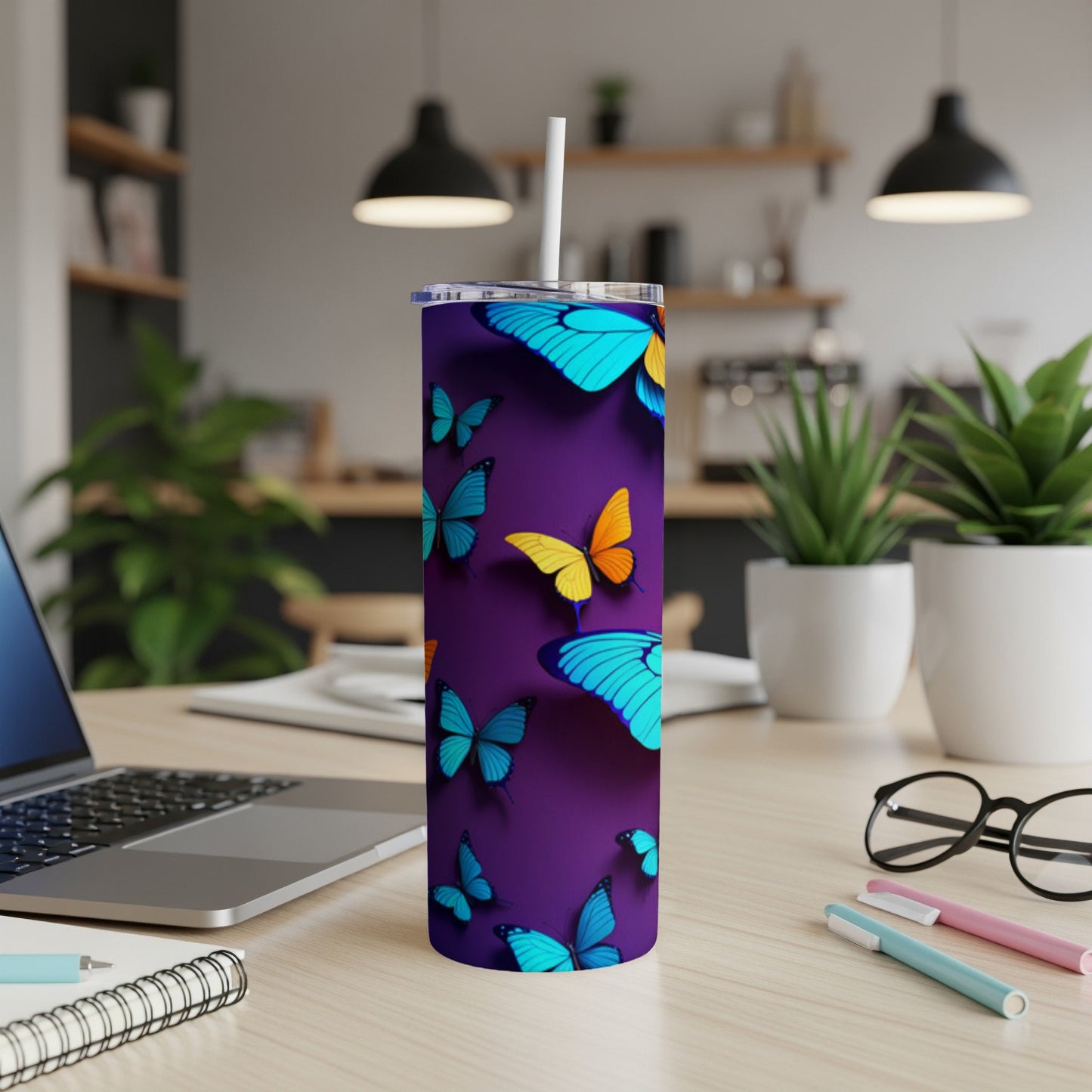 Purple tumbler with blue and yellow butterflies, on a desk.