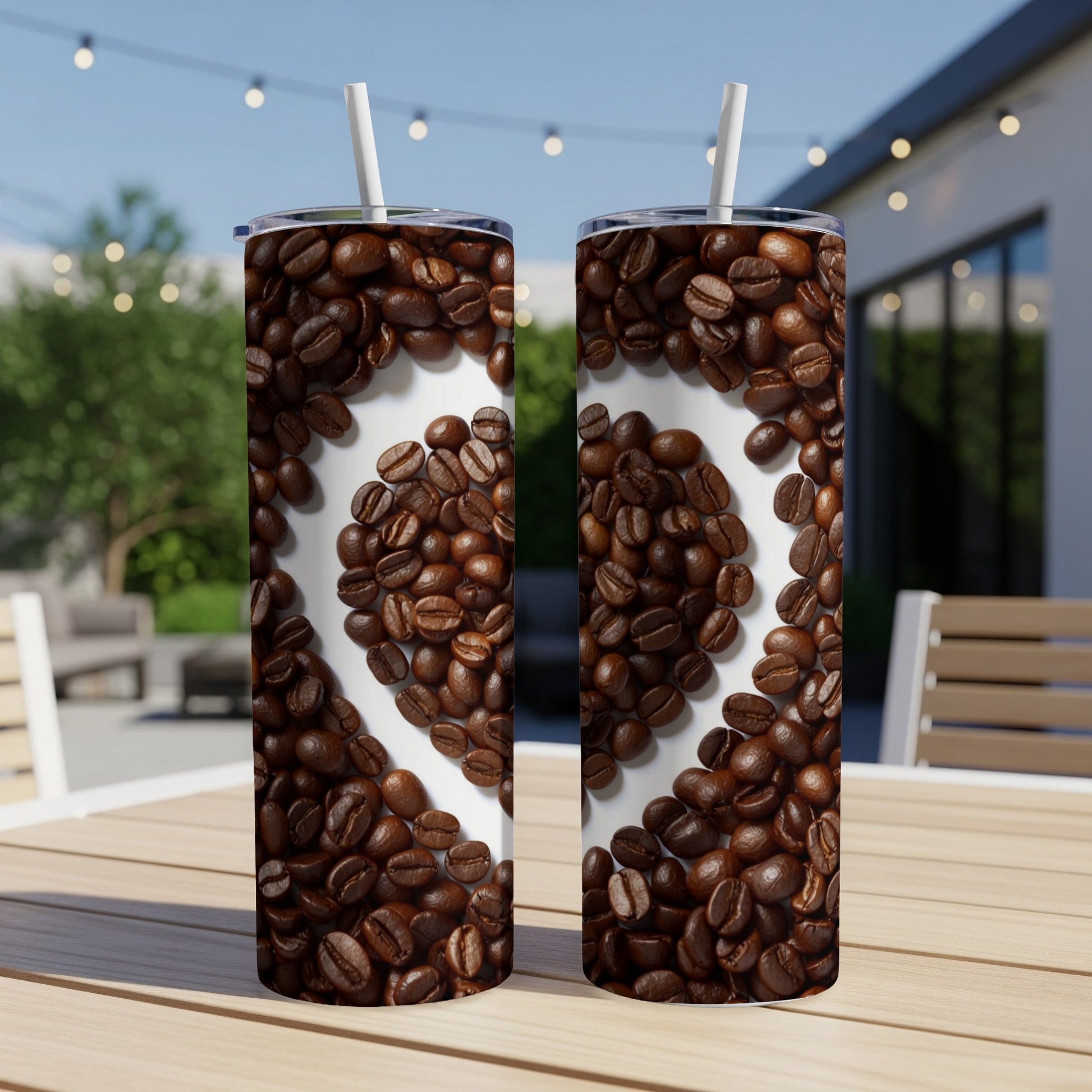 Two coffee tumblers with heart-shaped coffee bean design on outdoor table.