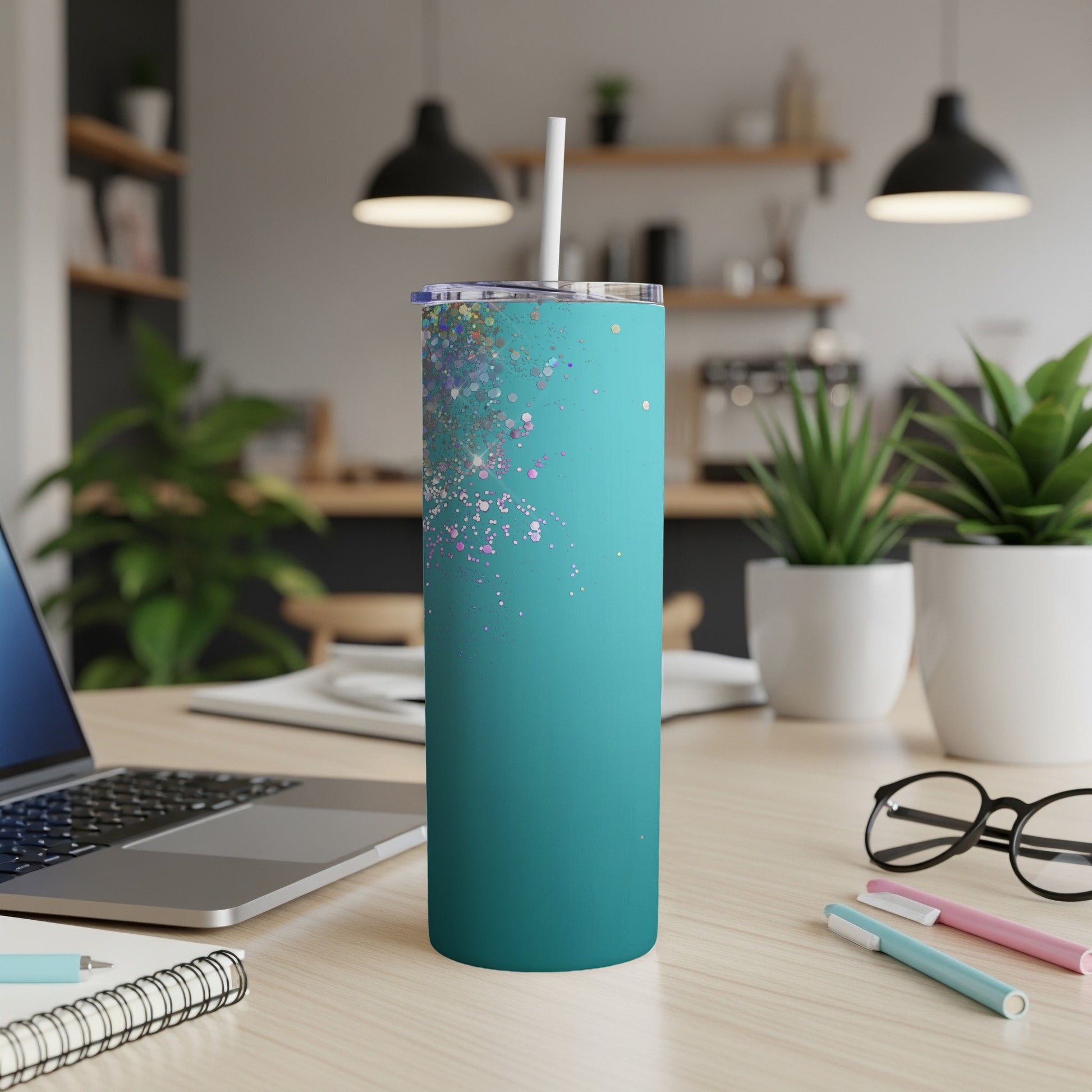 Teal tumbler with scattered iridescent glitter and white straw with lid.