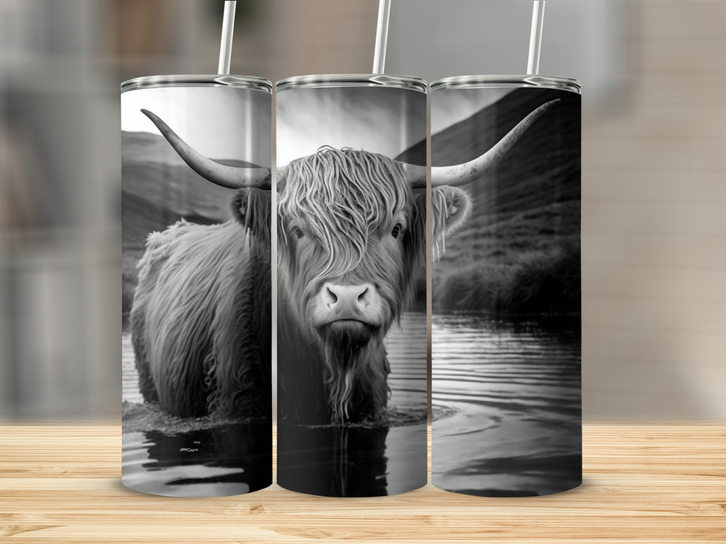 Highland cow standing in water with mountains in background on a tumbler.