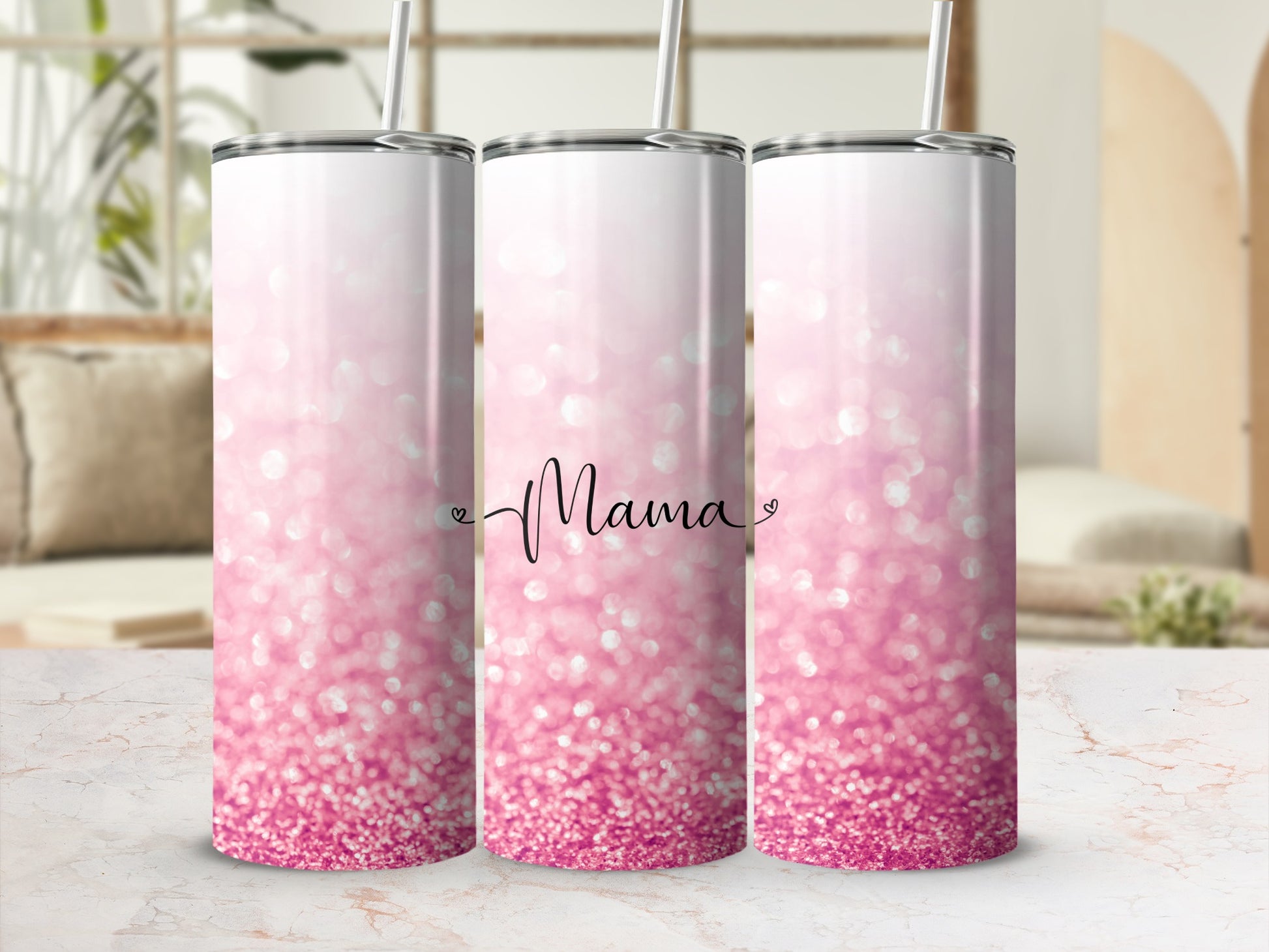 Pink glitter tumbler with "Mama" text, straw, and blurred background.