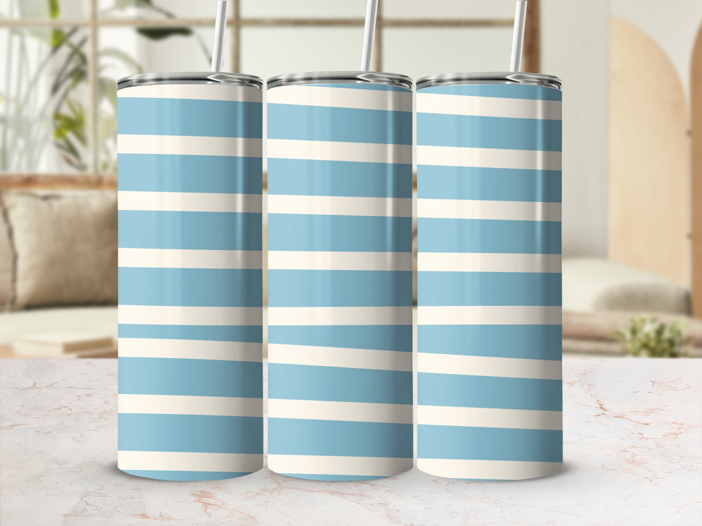 Three tumblers with blue and cream horizontal stripes and metal straws.