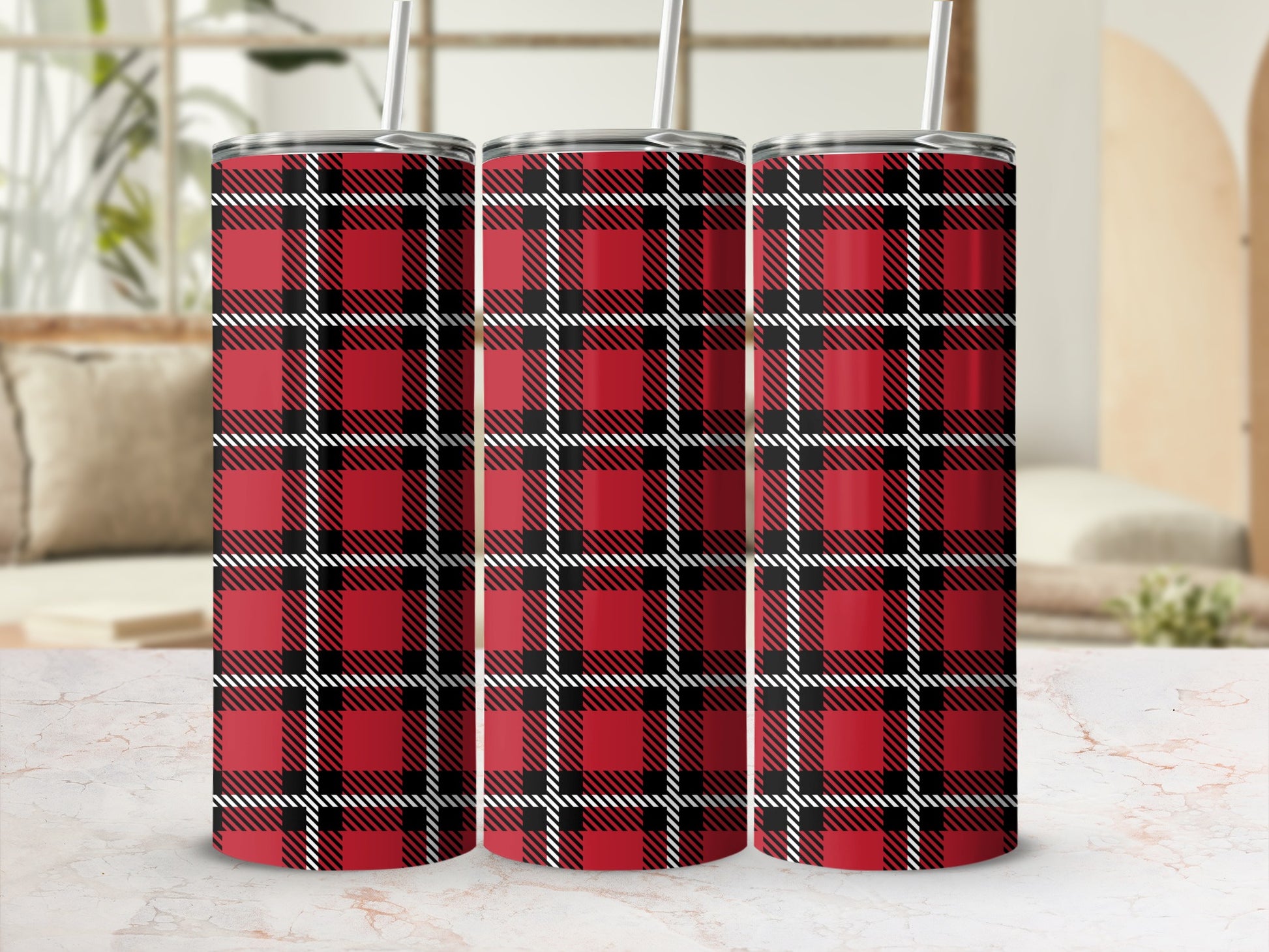 Three tumblers with a red, black, and white plaid pattern stand on a marble surface.