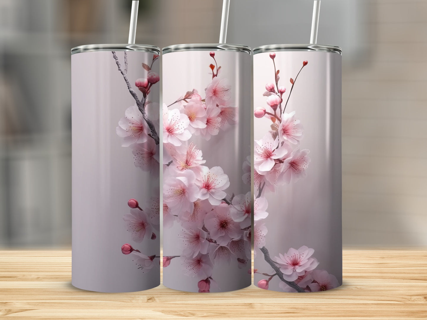Three tumblers with pink cherry blossoms against a blurred background.