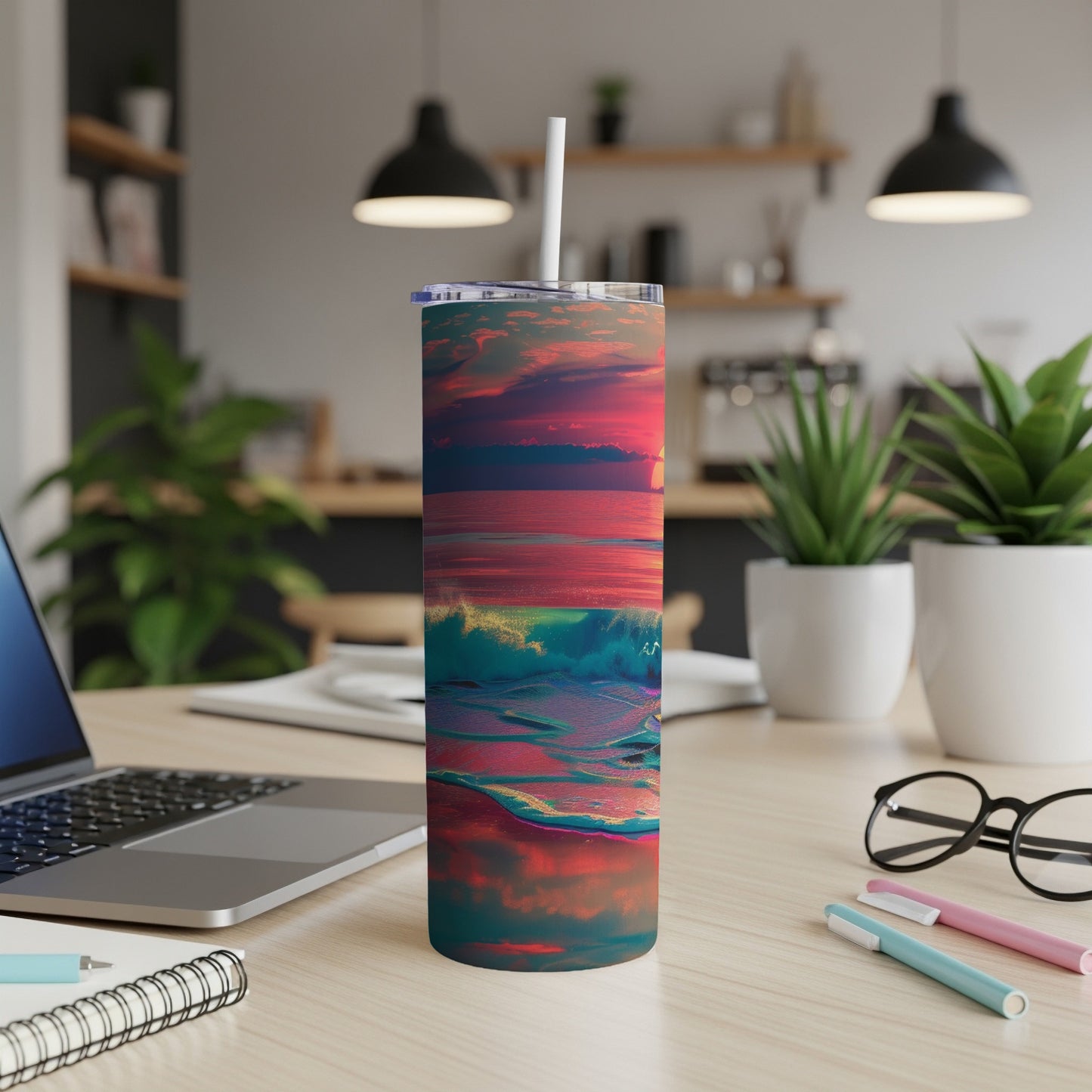 Tumbler with a colorful ocean sunset design on a desk.