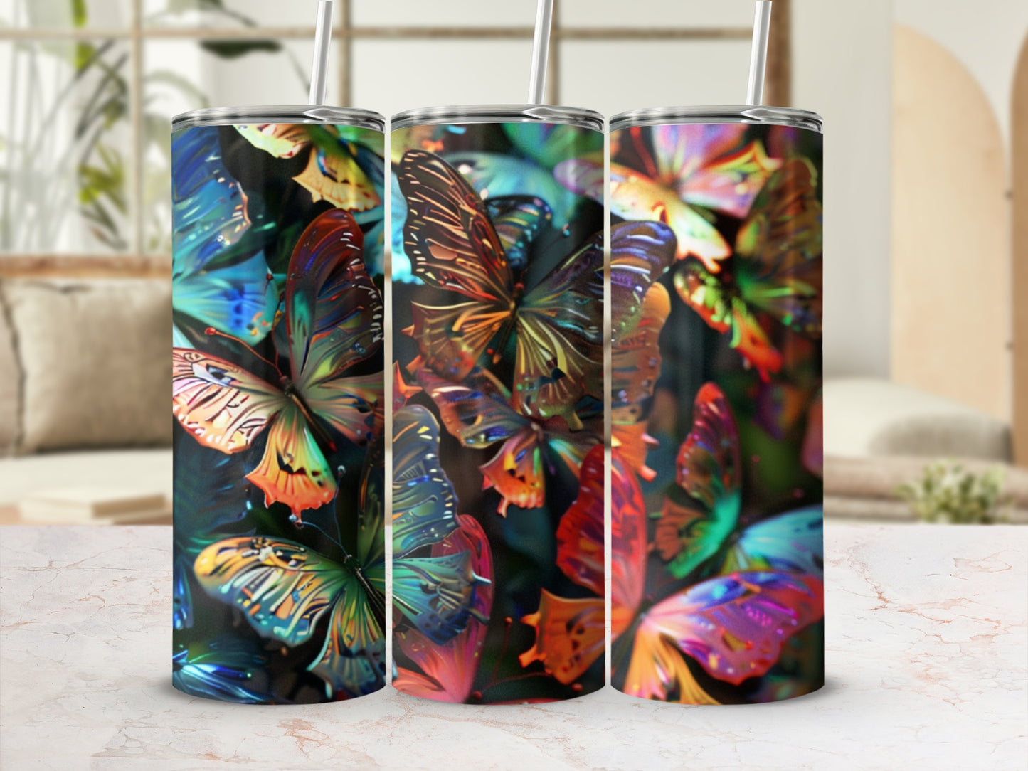 Three tumblers with iridescent butterfly designs and straws.