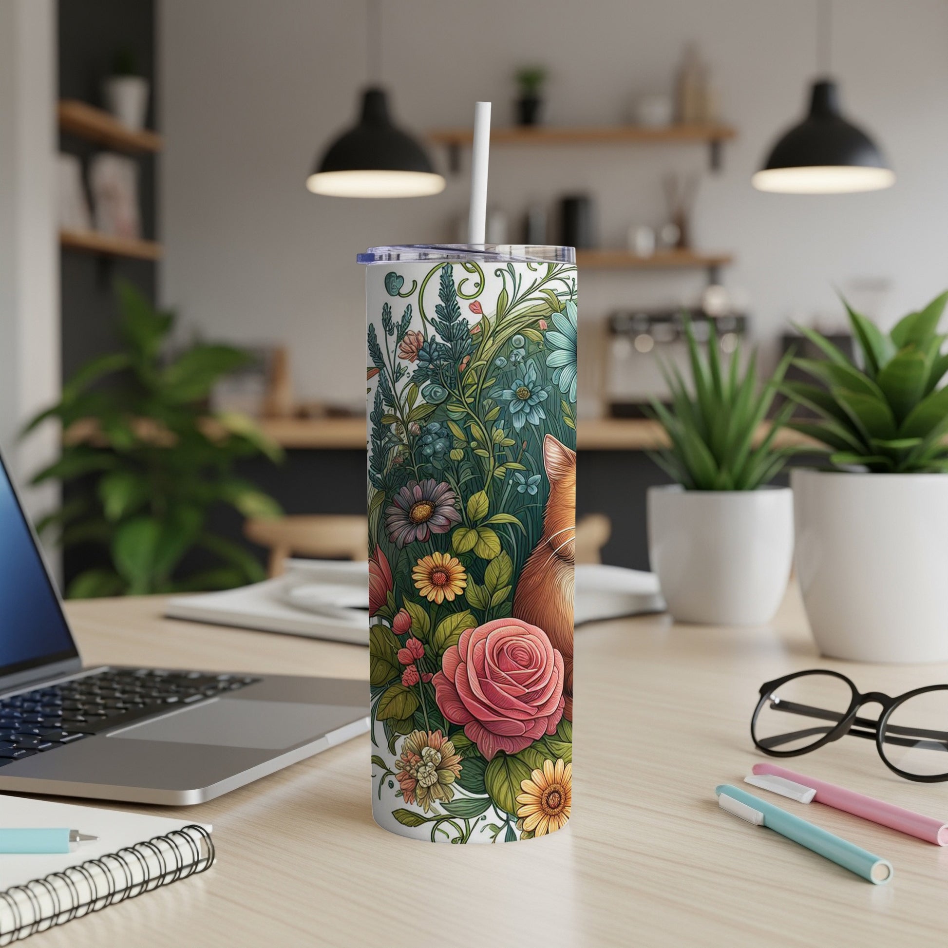 Tall tumbler with floral and fox design, white straw, on desk with laptop and pens.