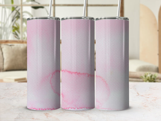 Three pink watercolor patterned tumblers with straws on a marble surface.