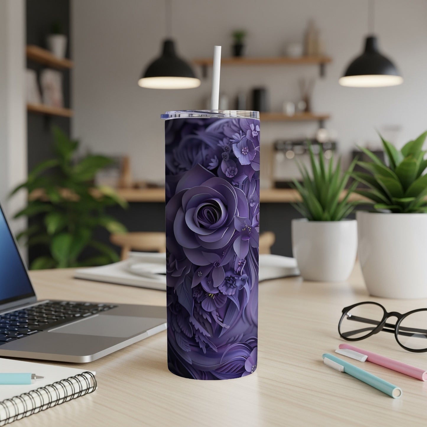 Purple floral pattern tumbler with a straw on a desk.