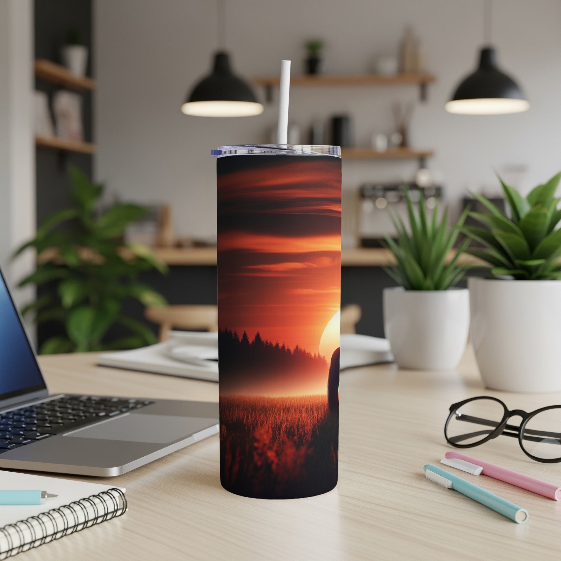 Tumbler with sunset over a field of trees, white straw.