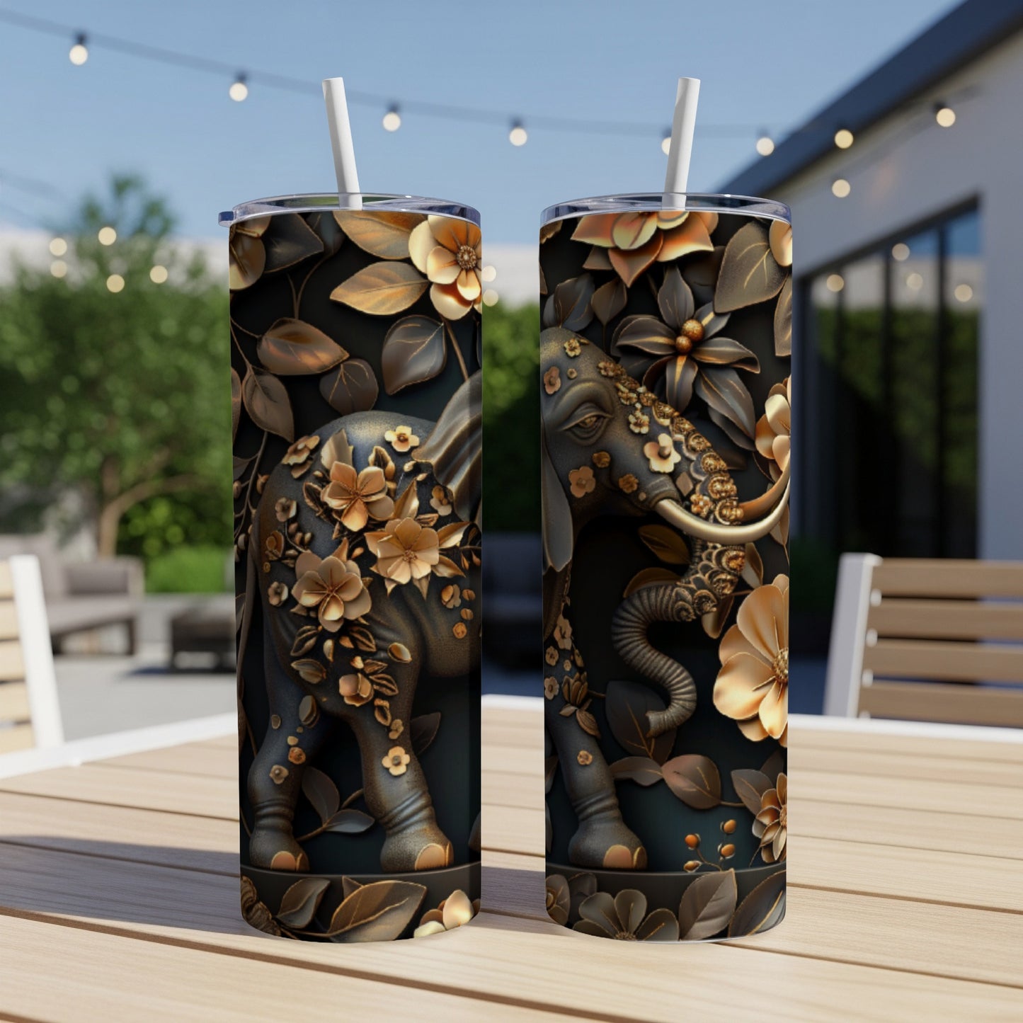 Two tumblers with detailed elephant and floral designs sit on a wooden table outdoors.