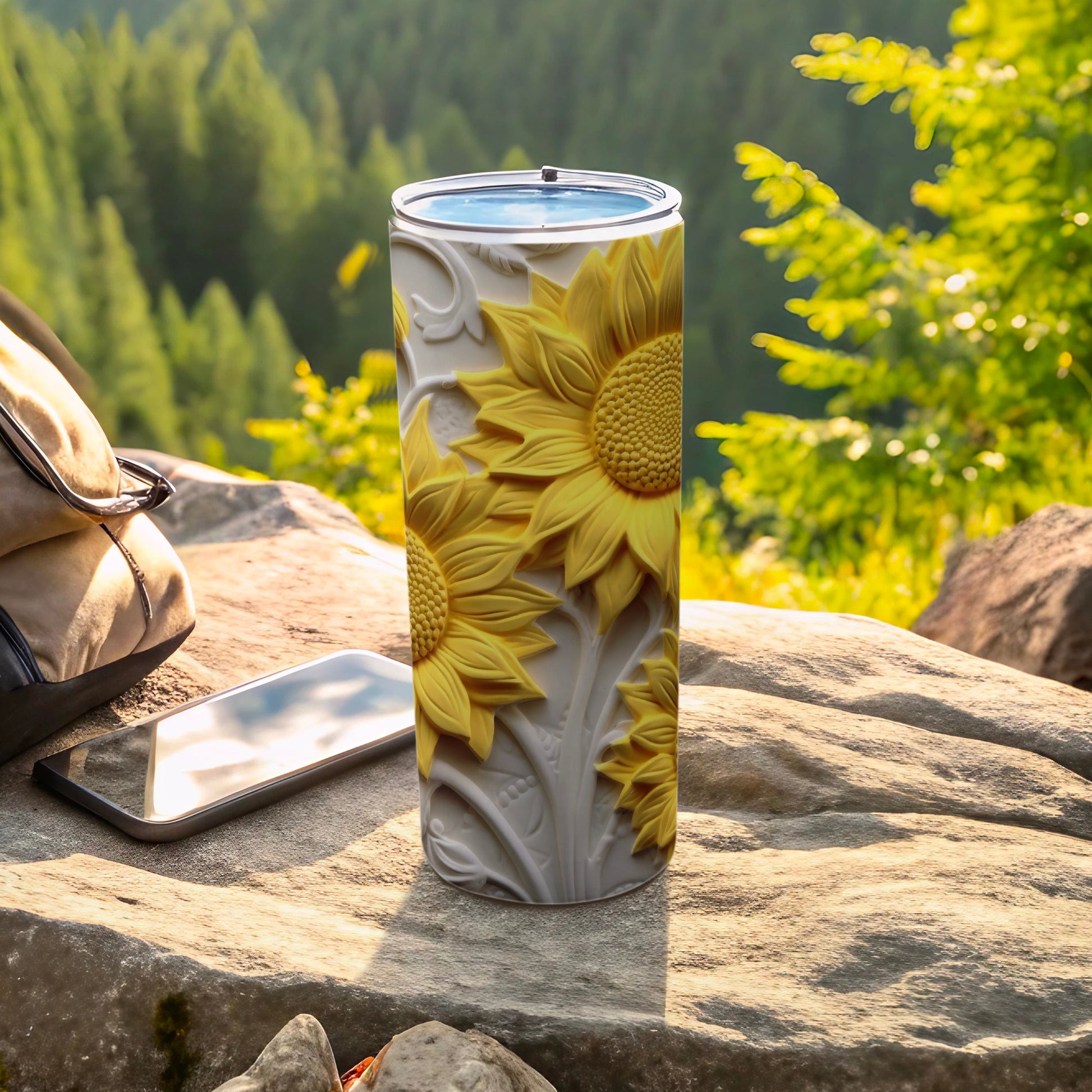 Sunflower tumbler with embossed floral pattern on a rock.