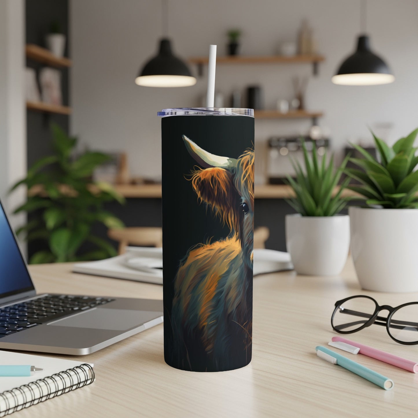 Highland cow illustration on a dark, sleek tumbler with a straw.
