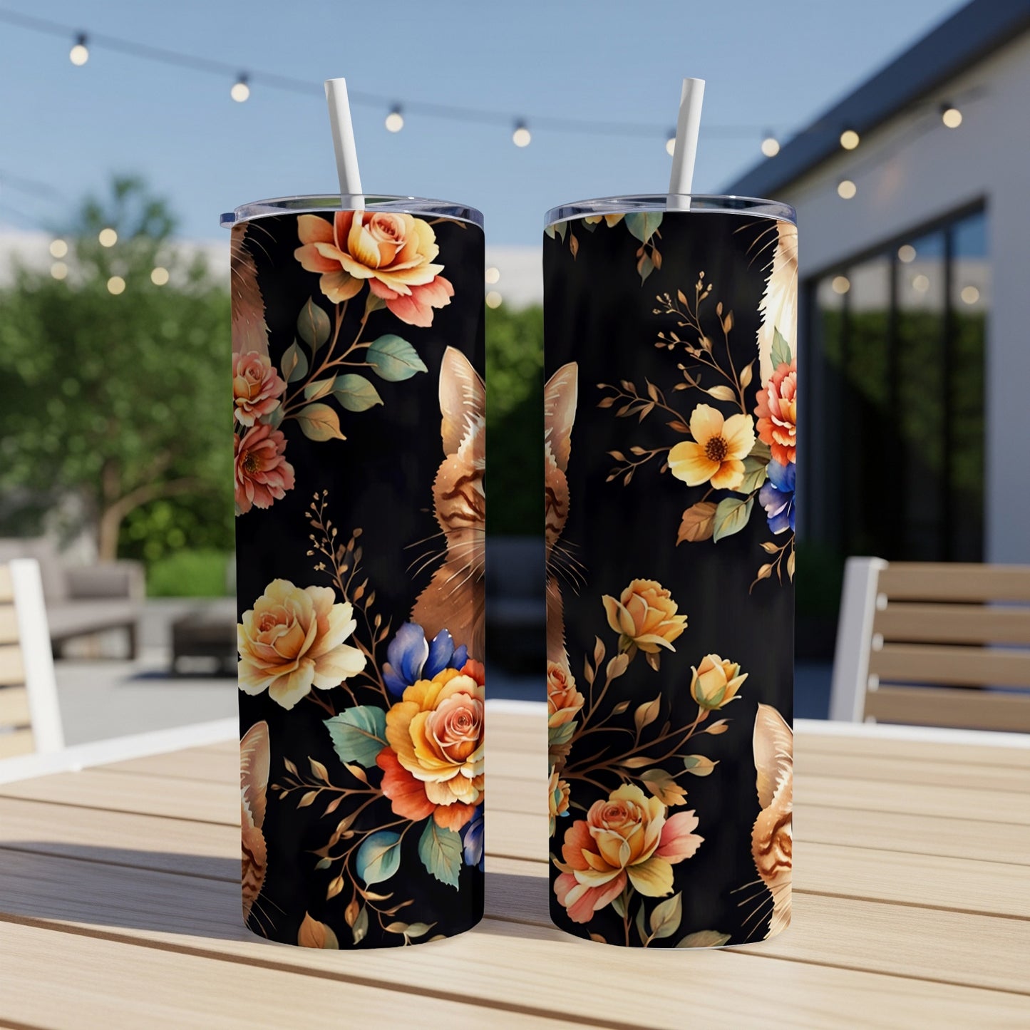 Two tumblers with a floral cat design on a table outdoors.