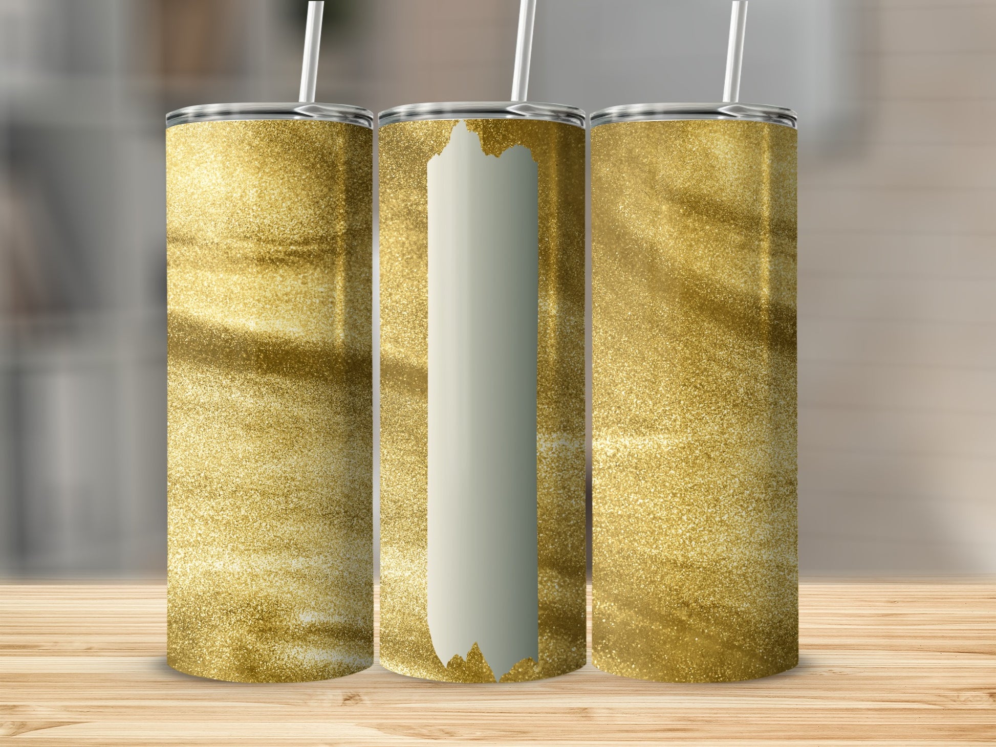 Three golden glitter tumblers with white vertical accents on a wooden surface.
