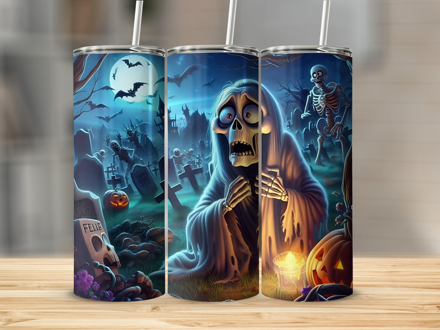 Halloween tumblers featuring a graveyard scene with ghosts, skeletons, and pumpkins.