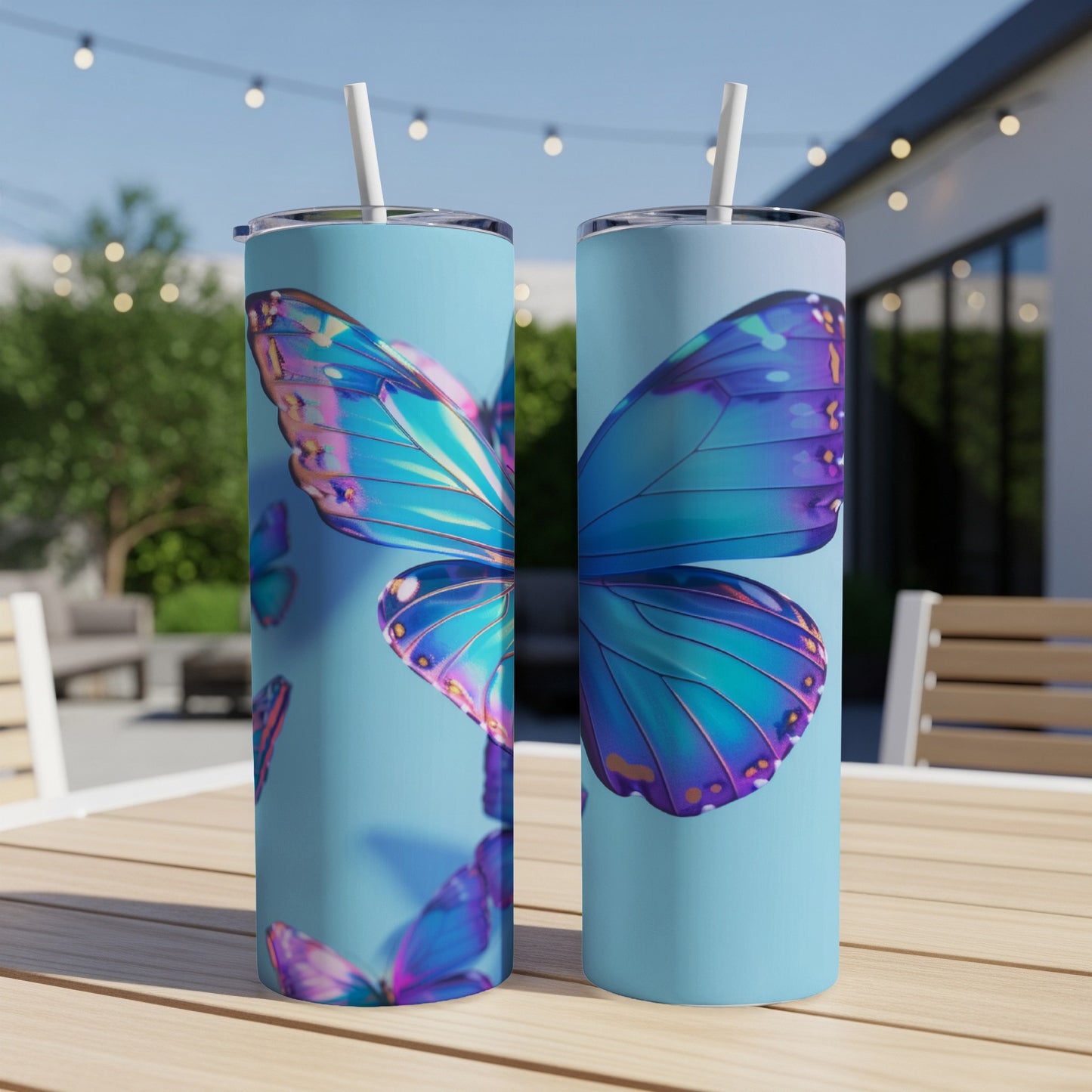 Two blue and purple butterfly tumblers with straws on a table.