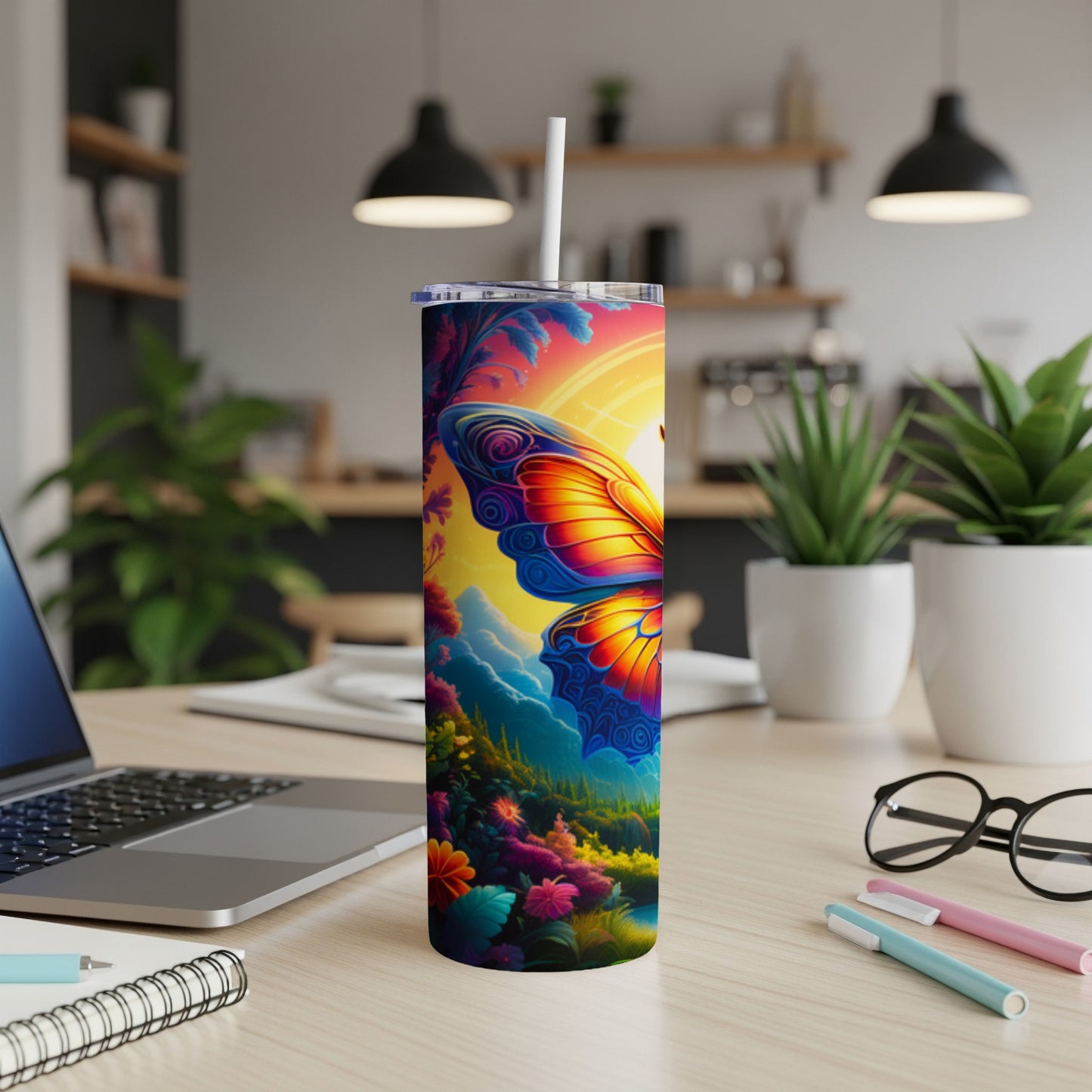 Tall tumbler with a vibrant butterfly and floral design on a desk.