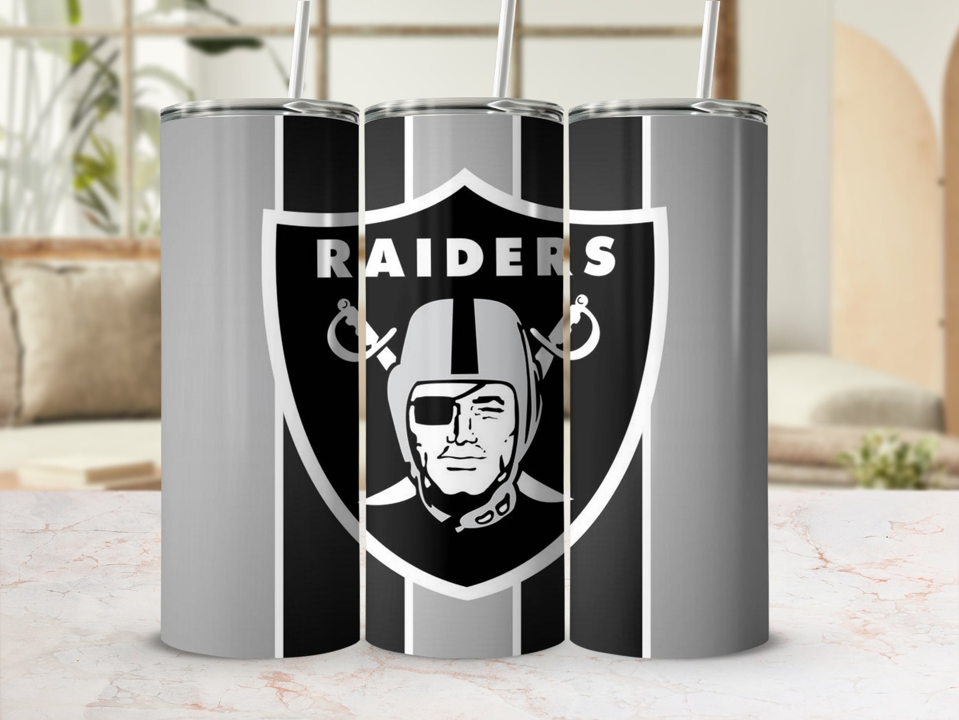 Las Vegas Raiders logo on three silver and black striped tumblers with straws.