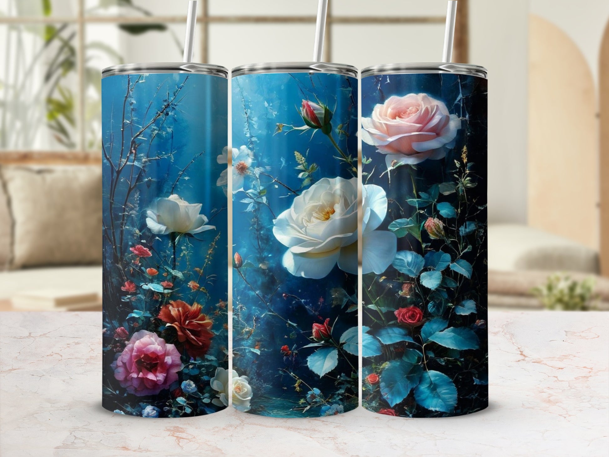 Three floral tumblers with roses and greenery on a marble surface.