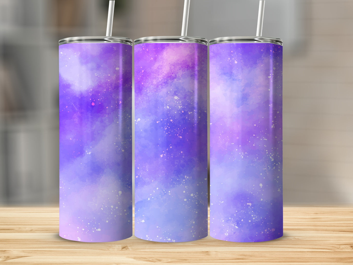 Three tumblers with purple and blue watercolor galaxy design and white speckles.