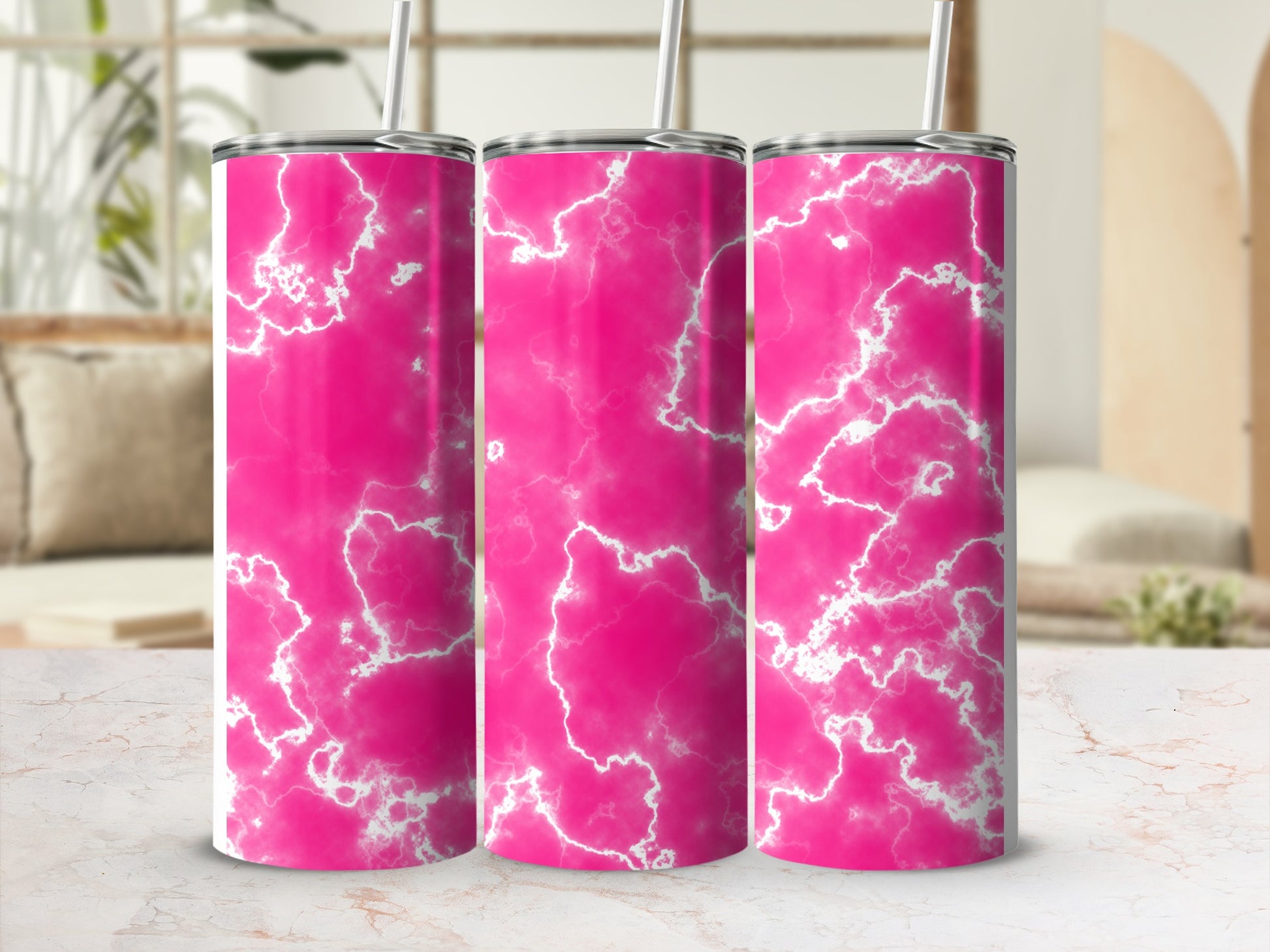 Three pink marble pattern tumblers with straws on a counter.