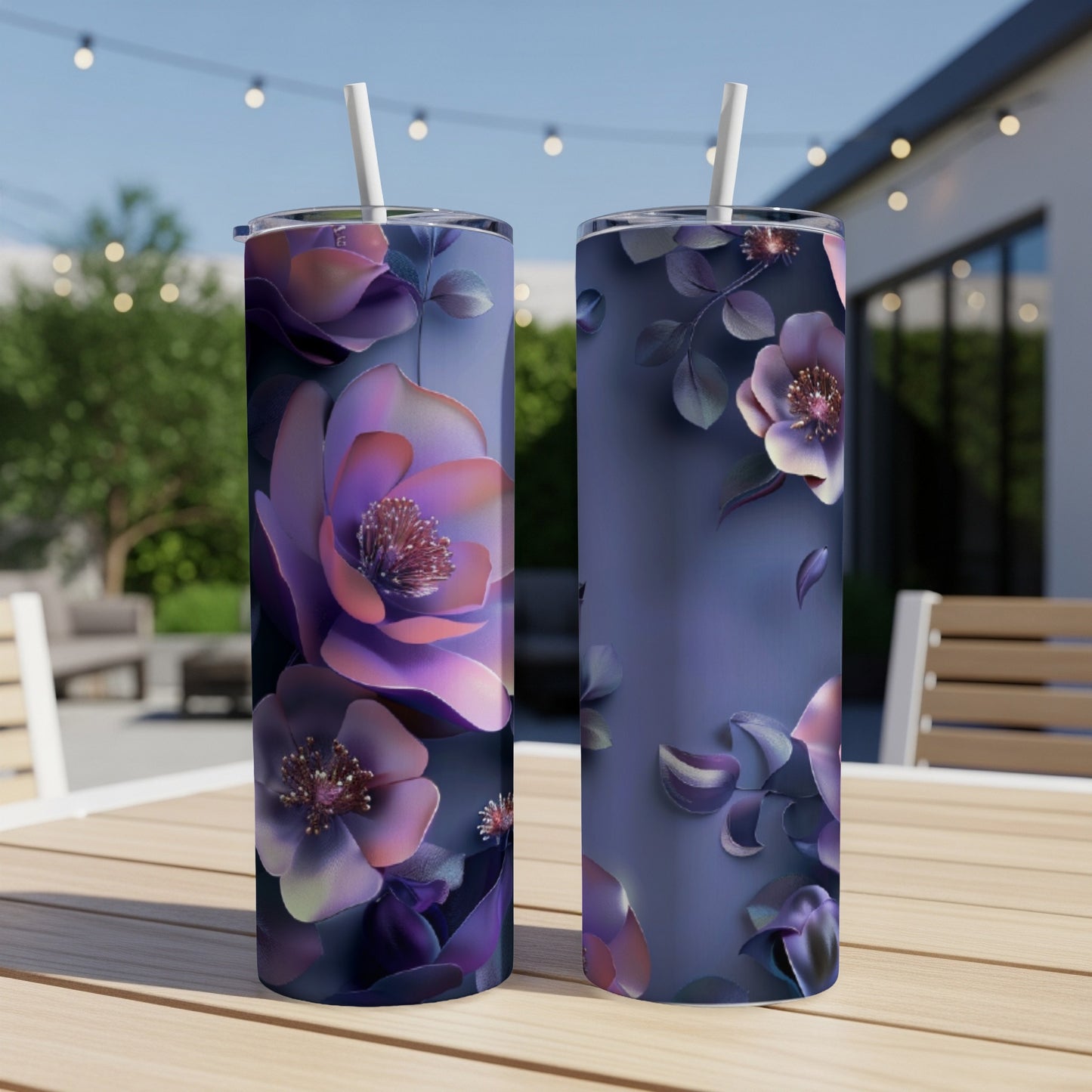 Two purple floral print tumblers with straws sit on a table.