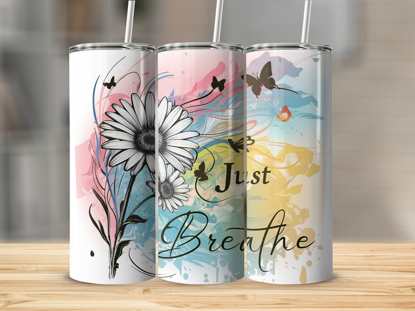 Three tumblers with floral and watercolor designs, one saying "Just Breathe."