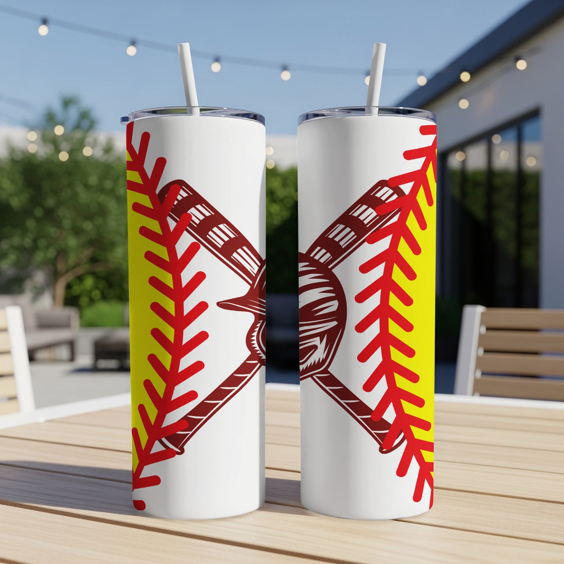 Two white tumblers with softball graphic design on a table.