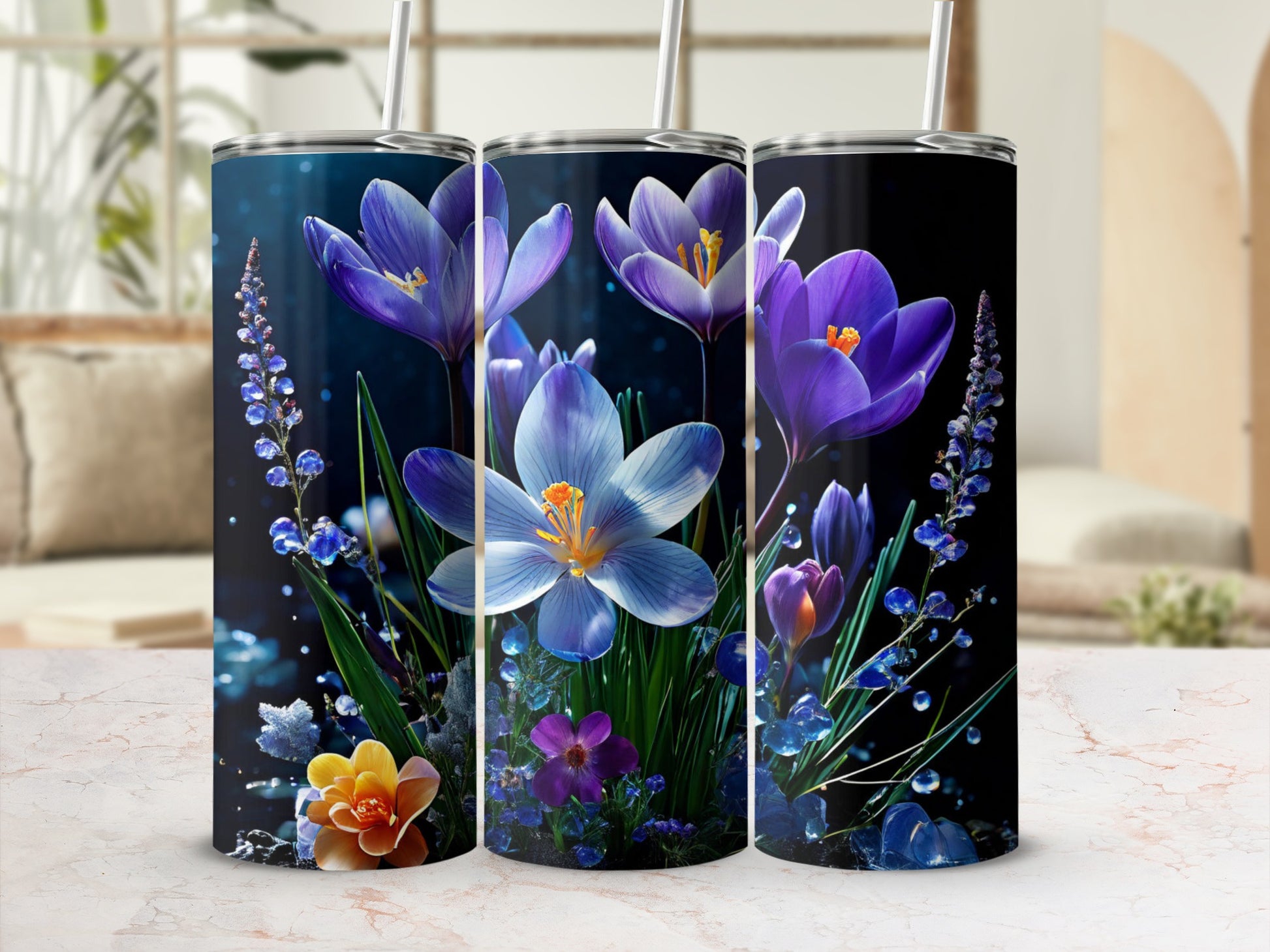 Three tumblers with purple and blue floral designs and straw lids.