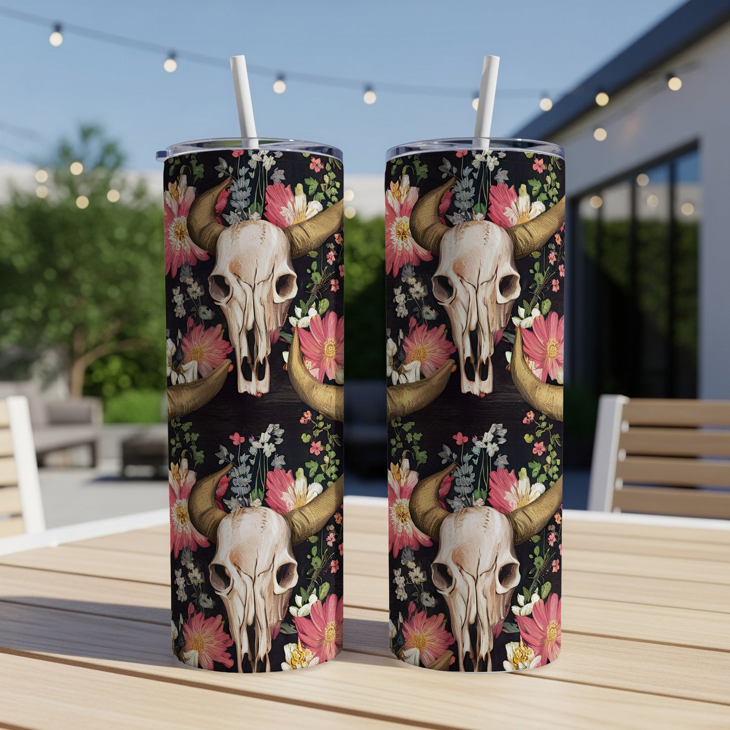 Two tumblers with steer skull and floral pattern on a table.