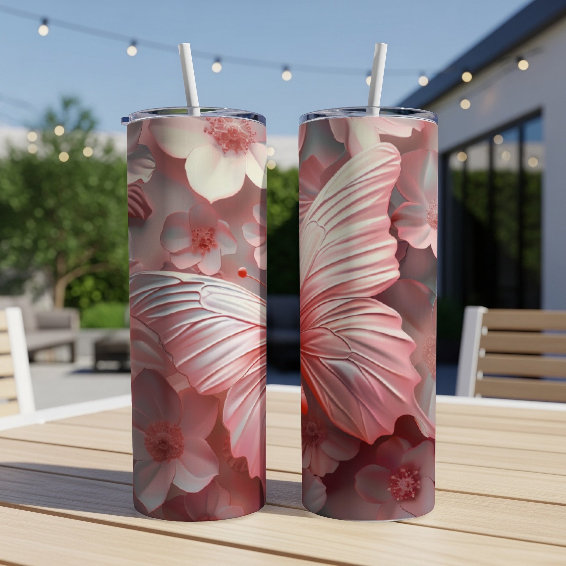 Two pink tumblers with a butterfly and floral design on a wooden table.