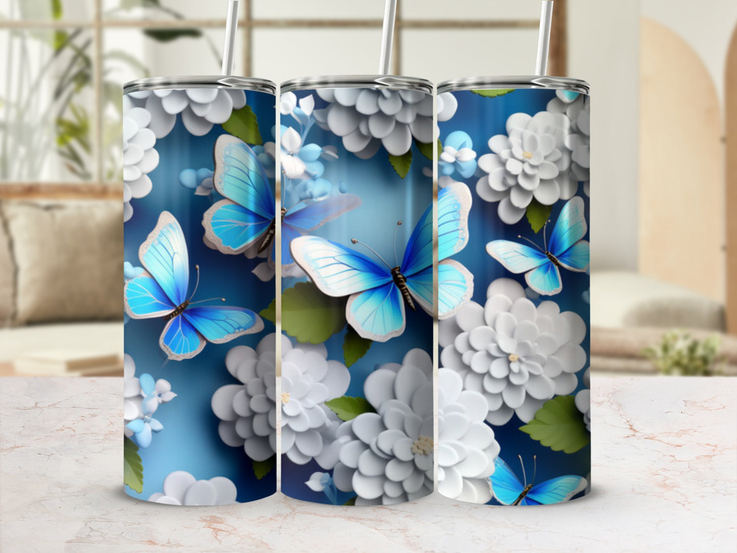 Blue butterflies and white flowers adorn a silver tumbler with straw.
