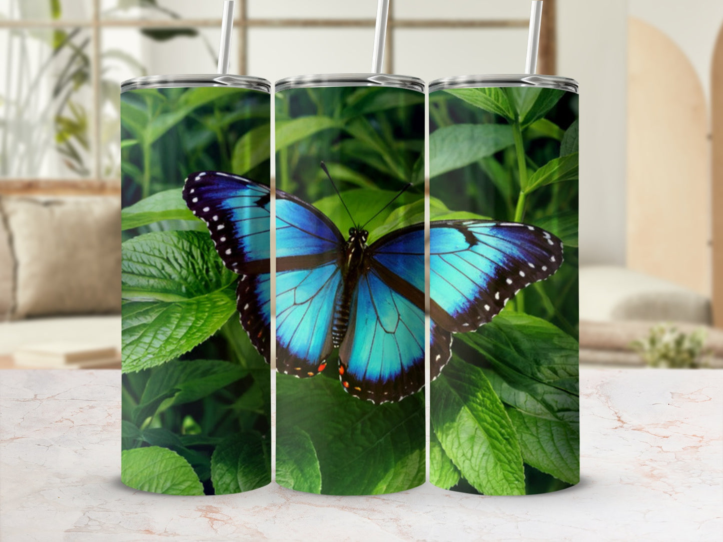 Blue butterfly on green leaves, presented on three tumblers.