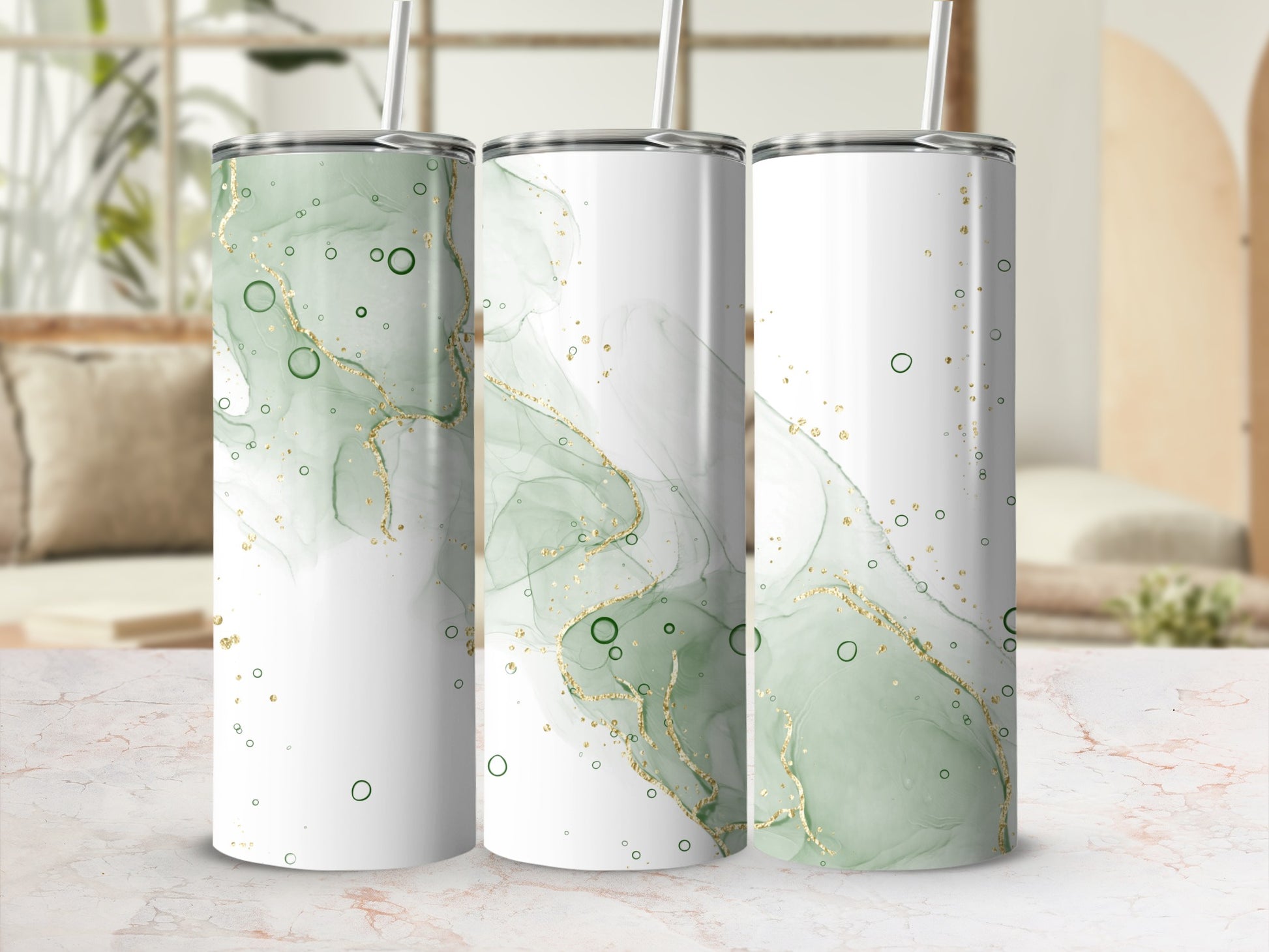 Three tumblers with a green and gold abstract marble design and straw.