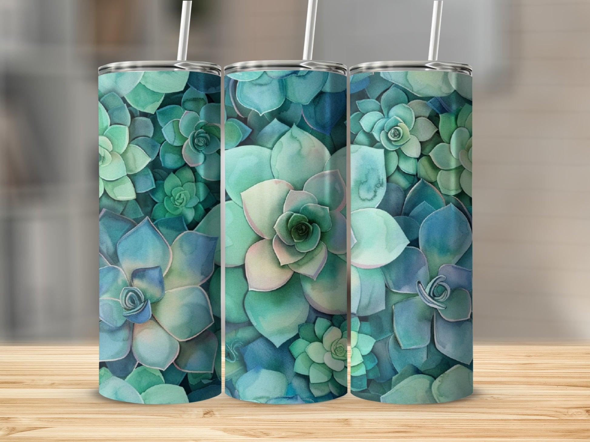 Three tumblers with a watercolor succulent pattern on a wooden surface.