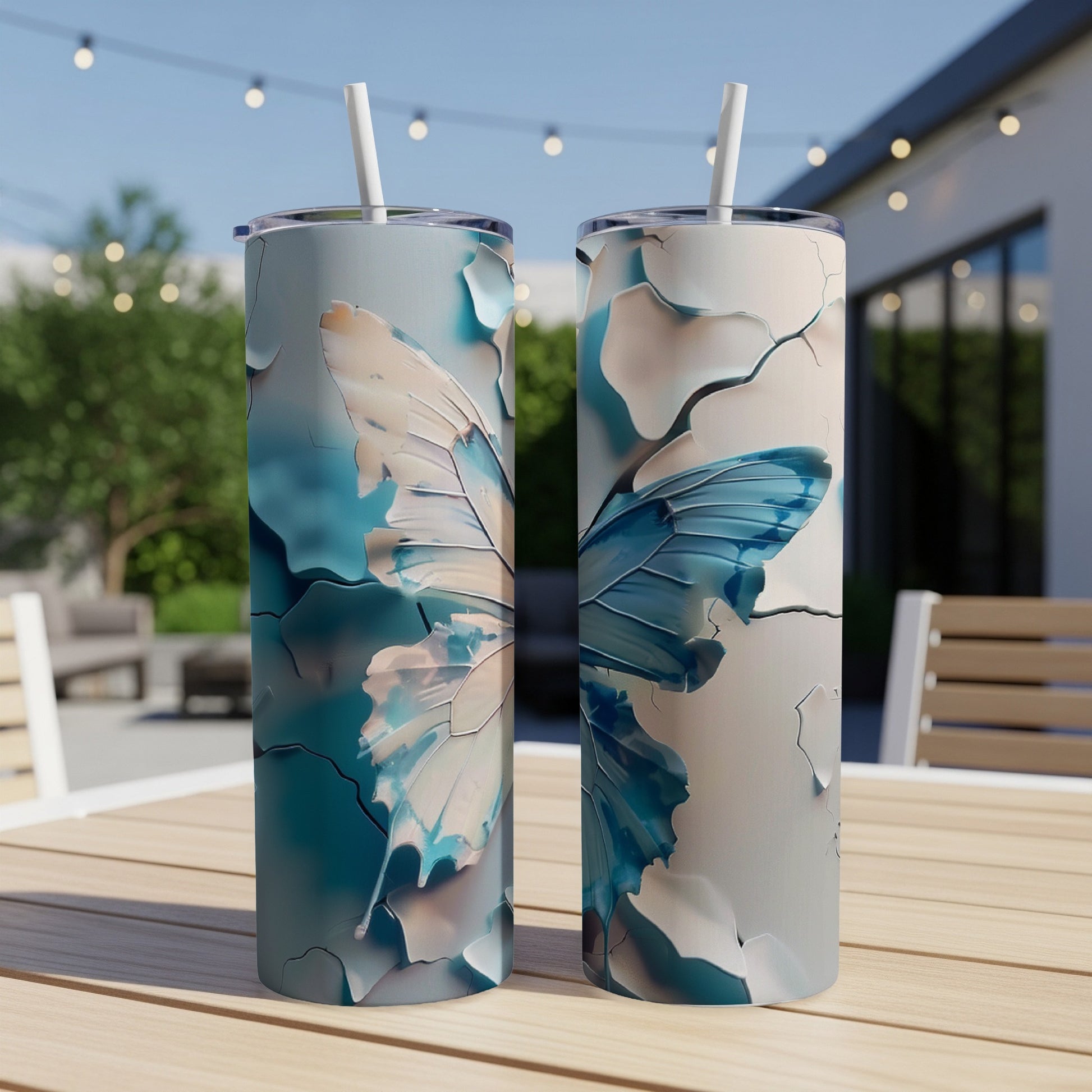 Two tall tumblers with a cracked butterfly wing design sit on a patio table.