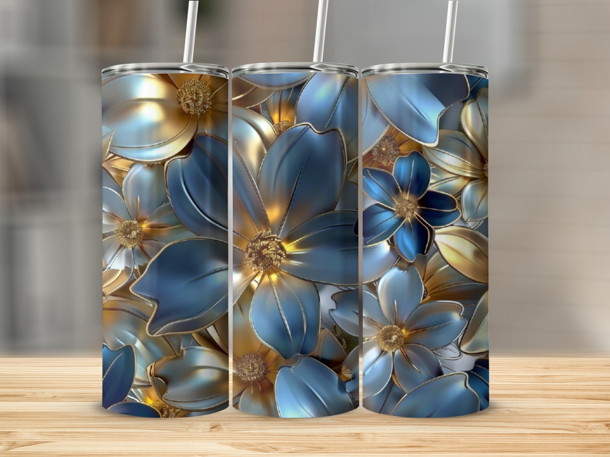 Three tumblers with blue and gold floral design on wooden surface.
